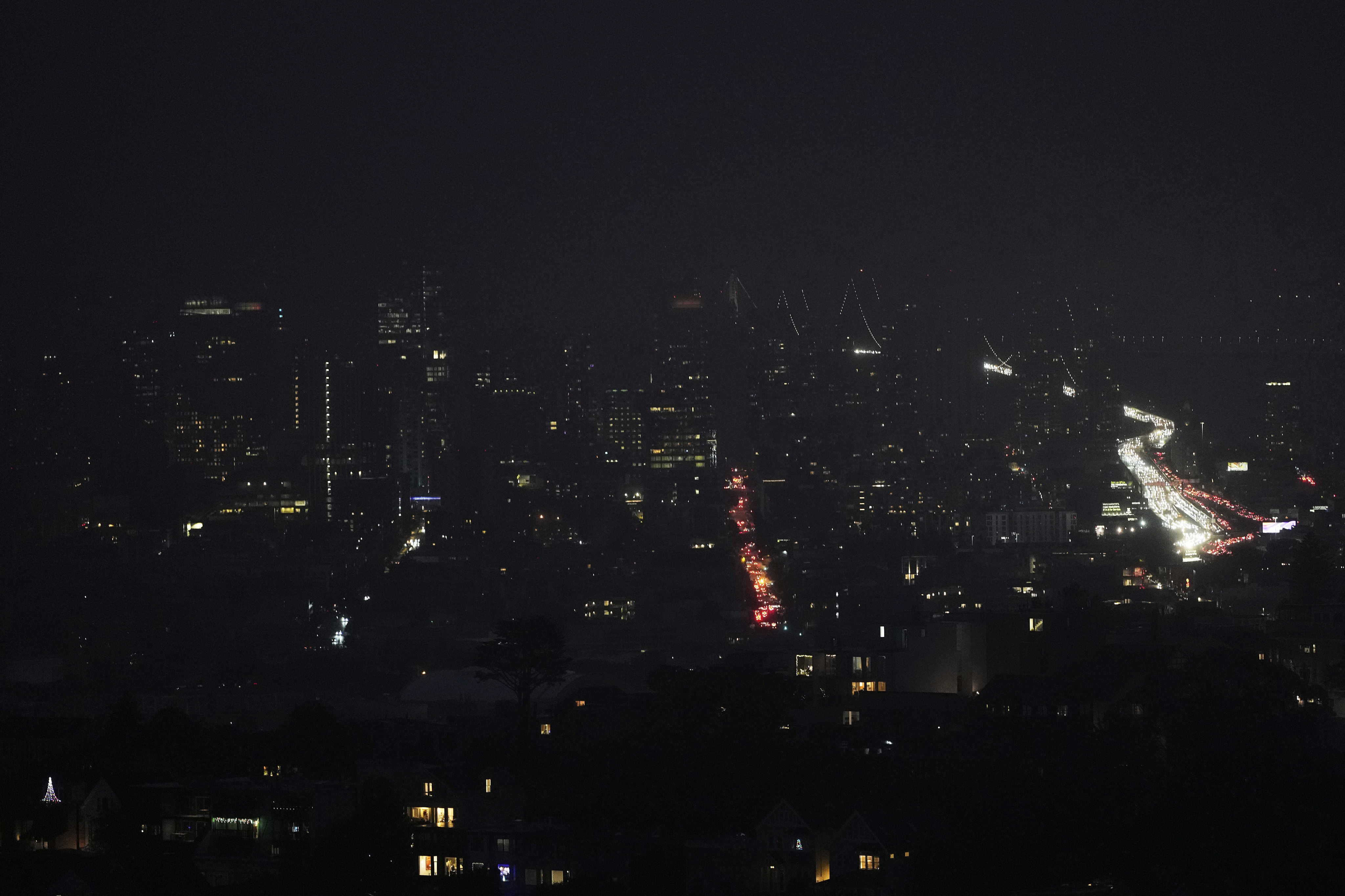 Fog and power outages darken the skyline as traffic moves in San Francisco on Saturday. Photo: AP