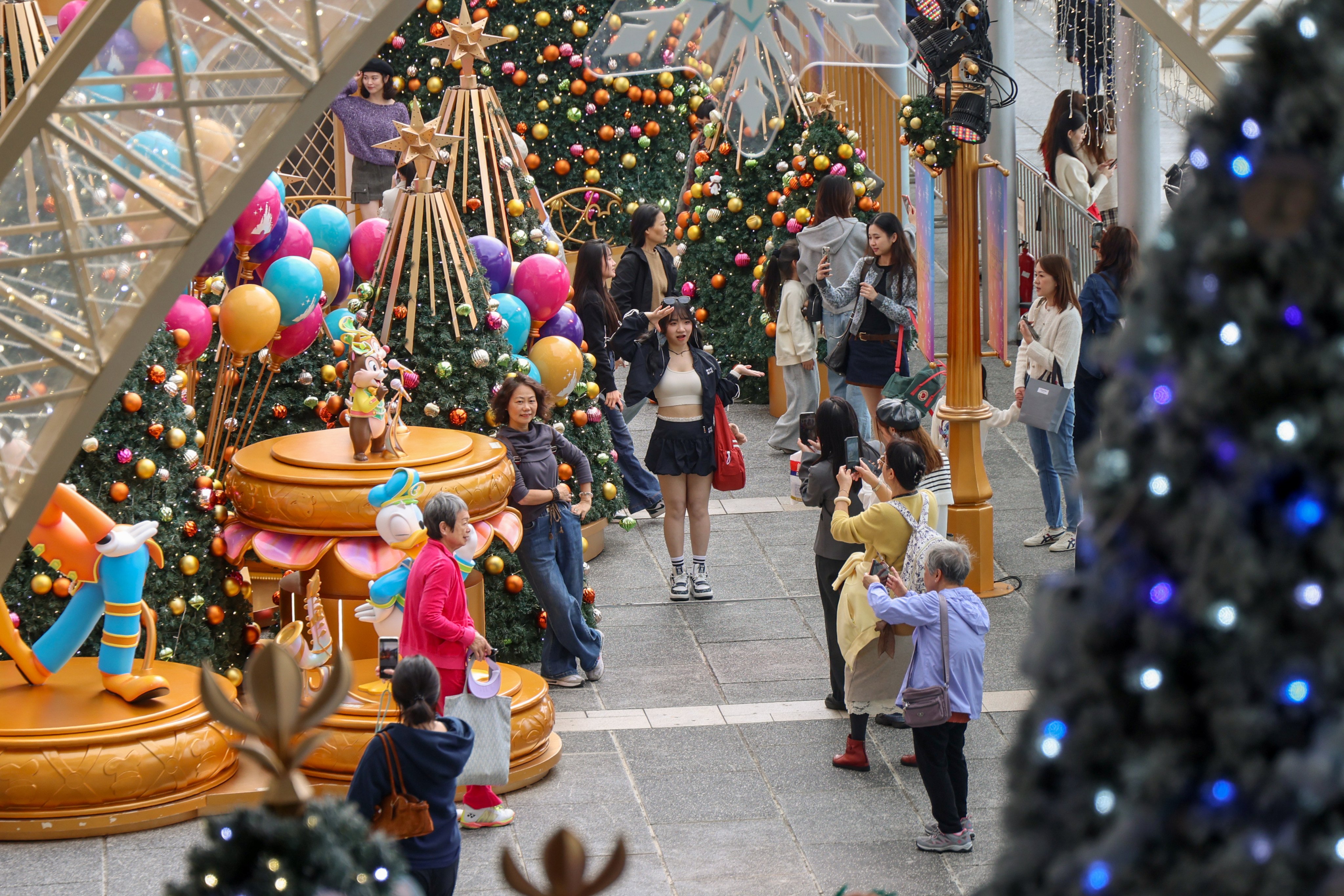 Tourists take photos under the Christmas decorations outside Ocean Terminal in Tsim Sha Tsui on December 19. Photo: Jelly Tse