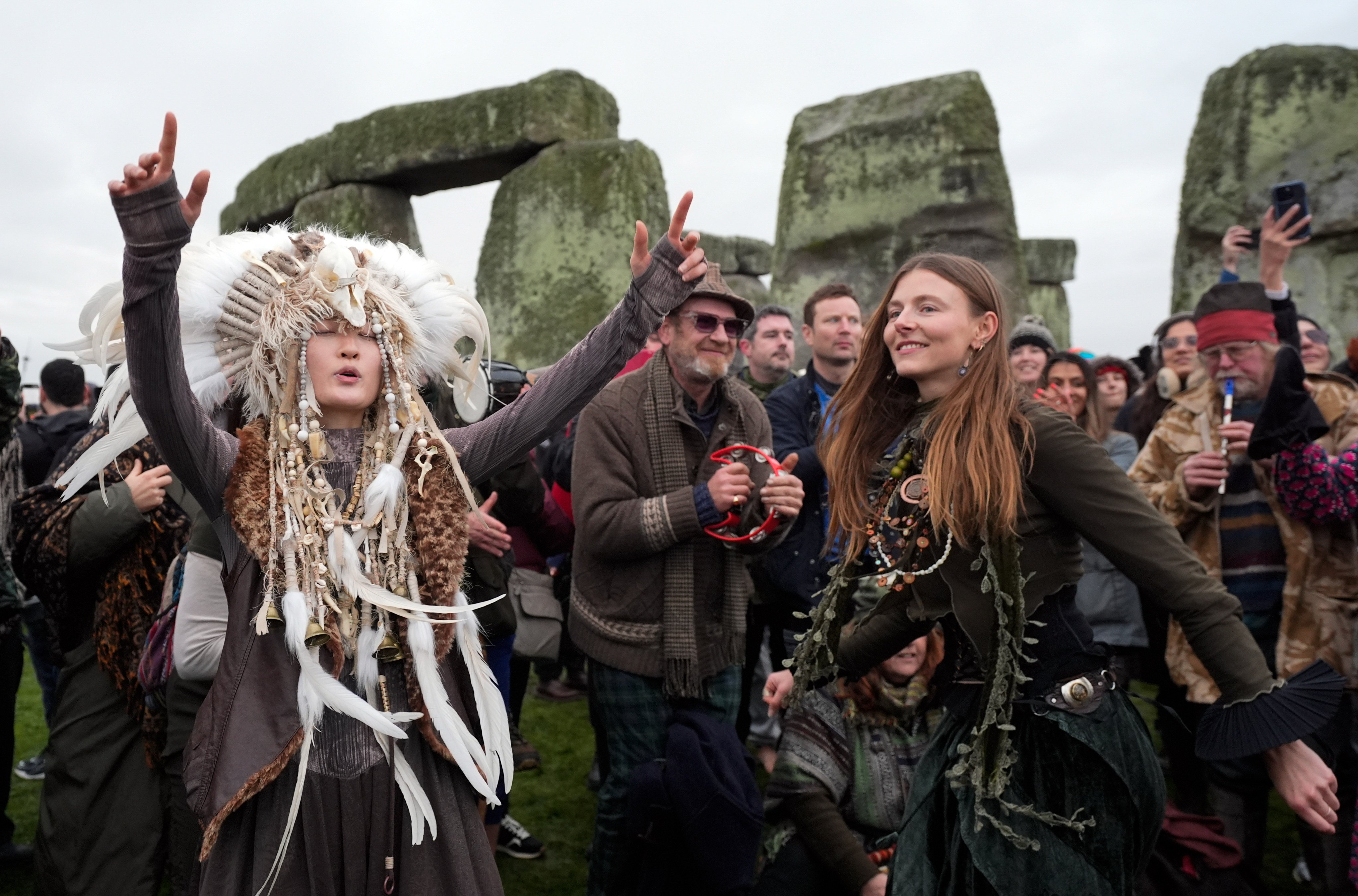 Kefan Wang, left, a fourth-generation Manchu Shaman, dances as people take part in the winter solstice celebrations during sunrise at the Stonehenge prehistoric monument on Salisbury Plain in Wiltshire, England on Sunday. Photo: PA Wire / dpa
