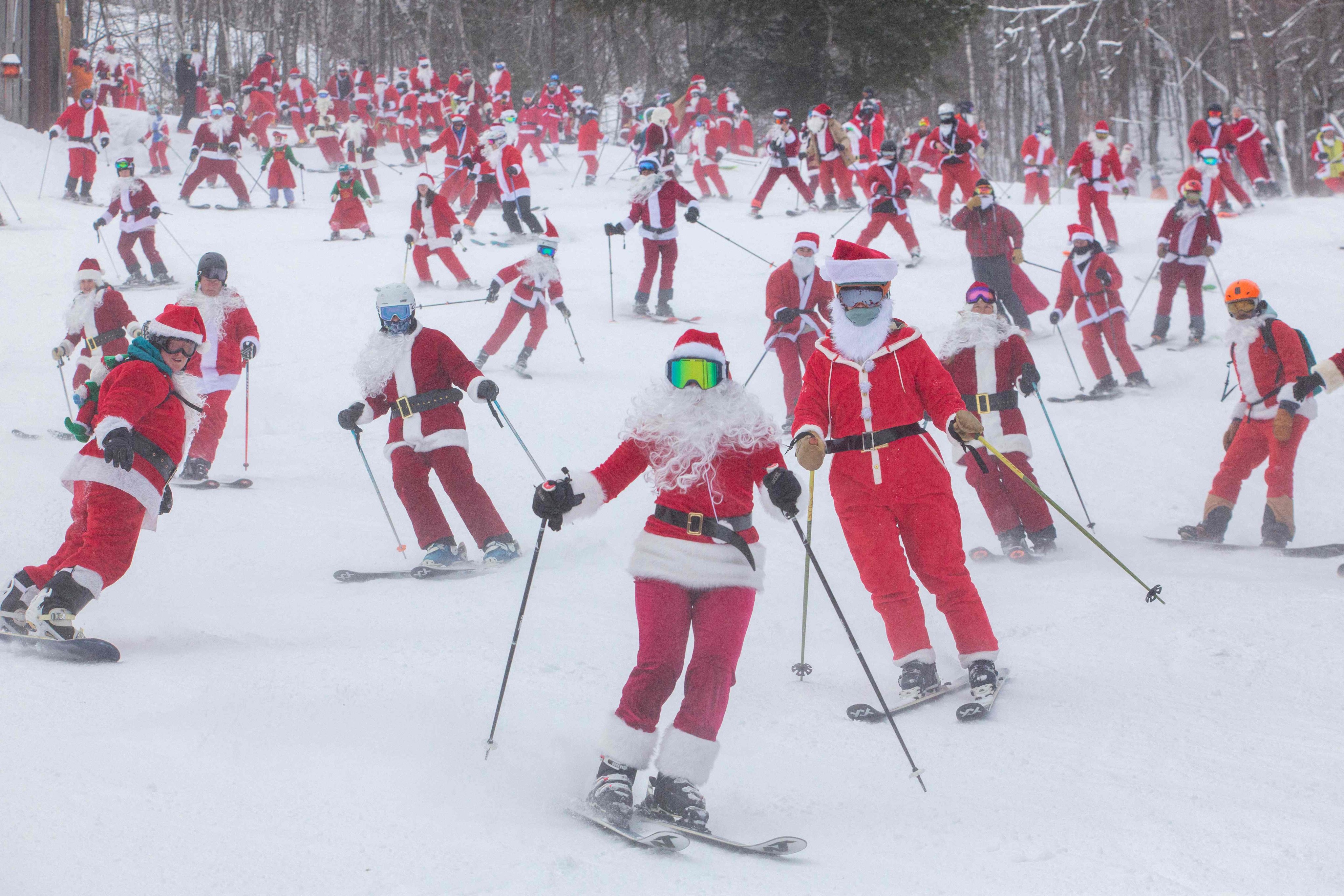 People dressed in Santa Claus costumes ski down South Ridge at Sunday River resort in the US state of Maine to raise money. Photo: AFP