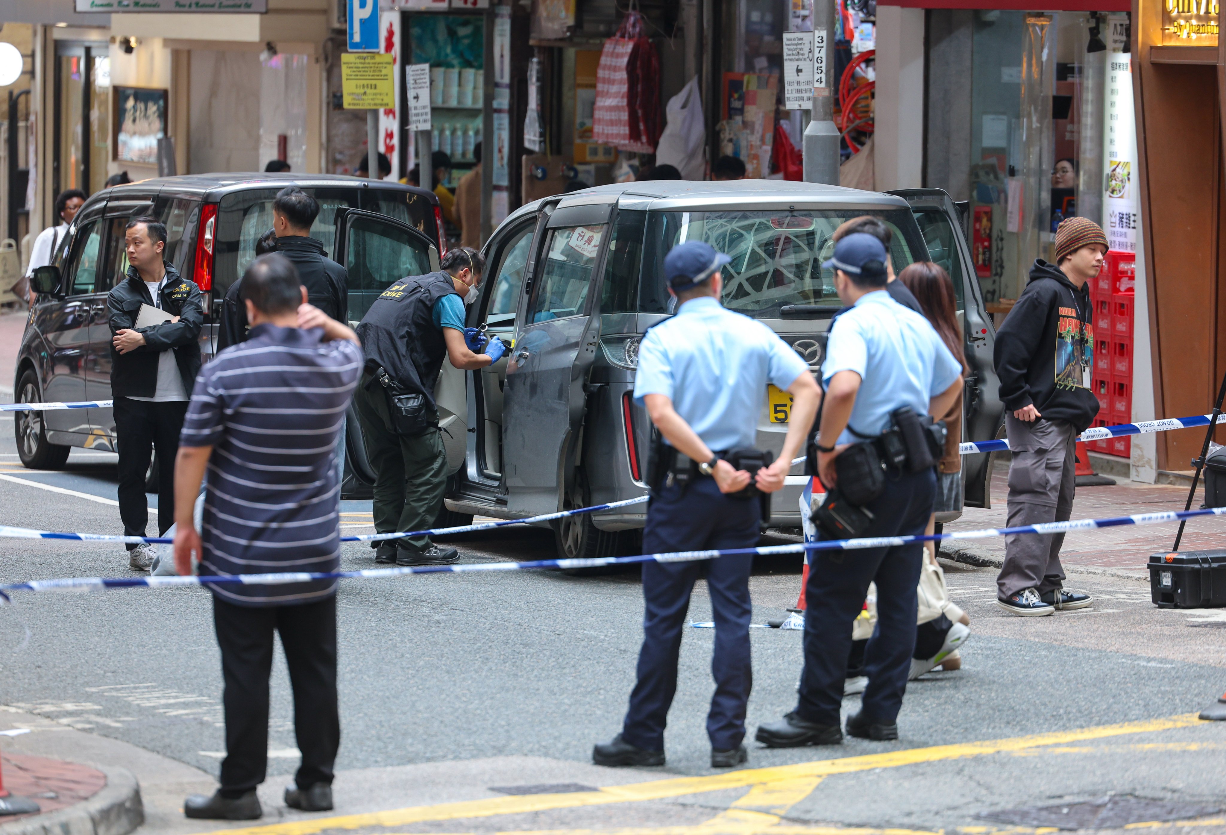 A police officer searches and collects evidence from a car on Jervois Street, Sheung Wan, believed to be linked to the robbery. Photo: Edmond So