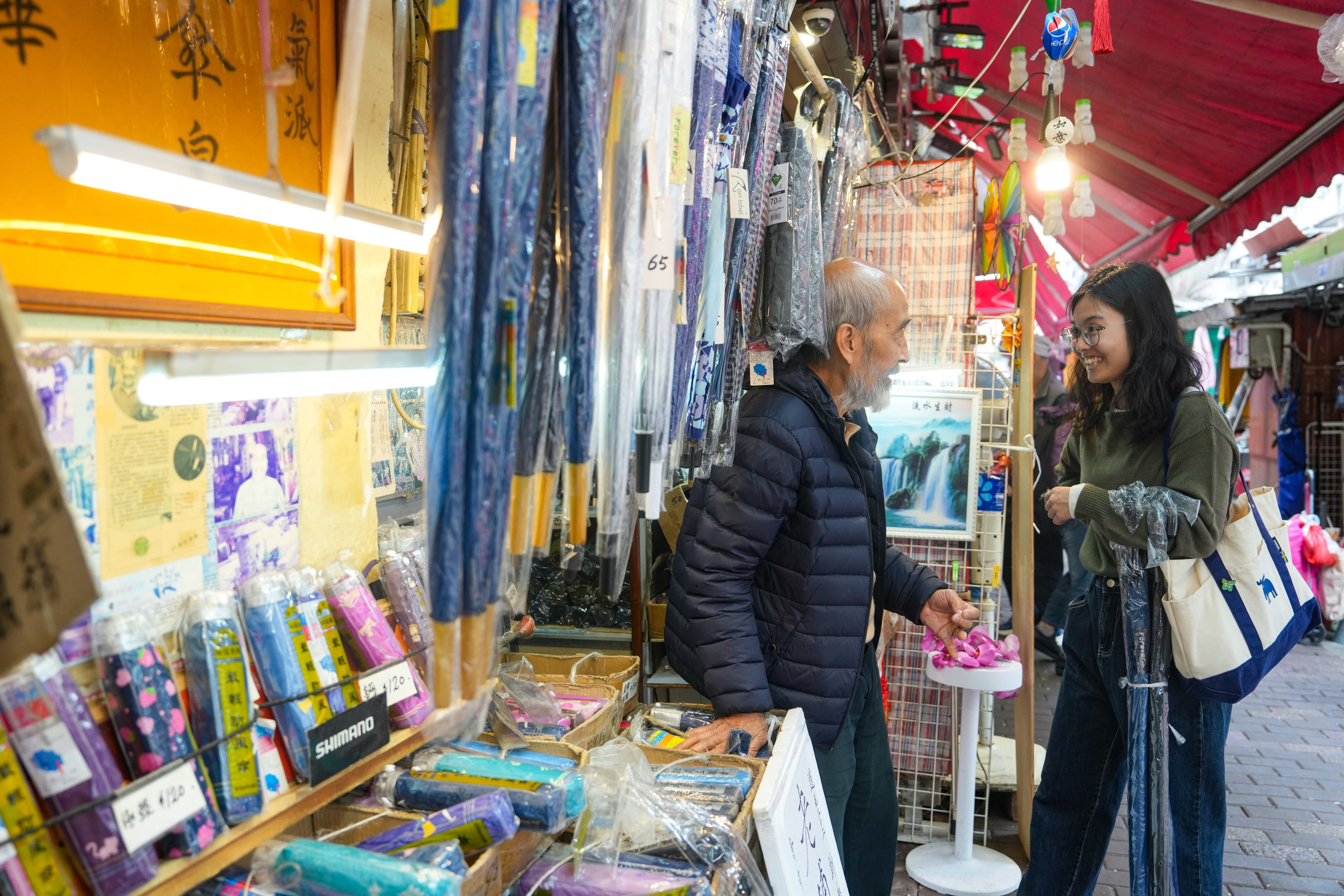 Yau Yiu-wai (black jacket), 73, owner of Sun Nga Shing Umbrella Store in Sham Shui Po, has decided to close his 183-year-old business by the end of this month. Photo: Sam Tsang