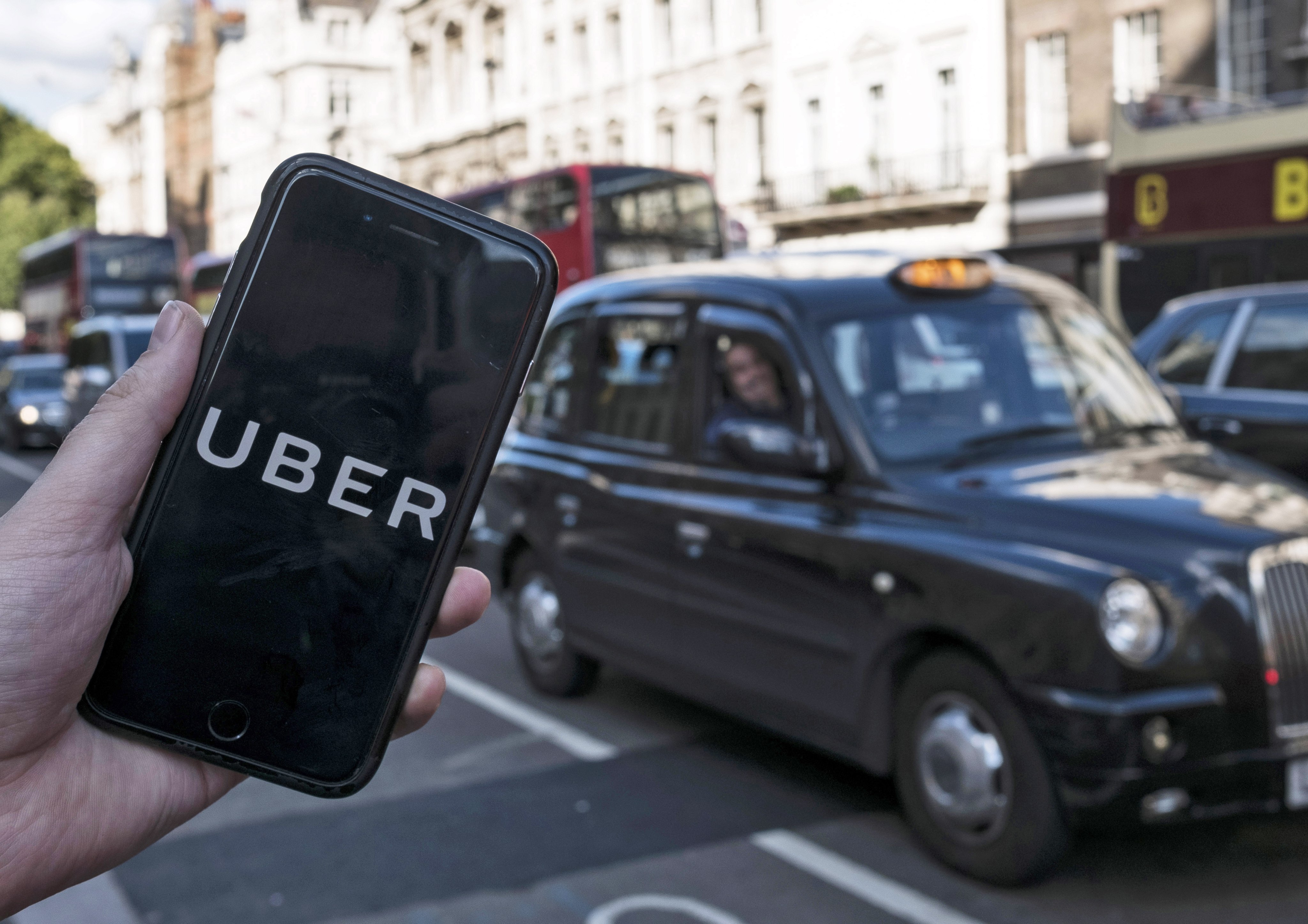 An arranged image shows the Uber logo on a mobile phone in central London. Photo: EPA-EFE