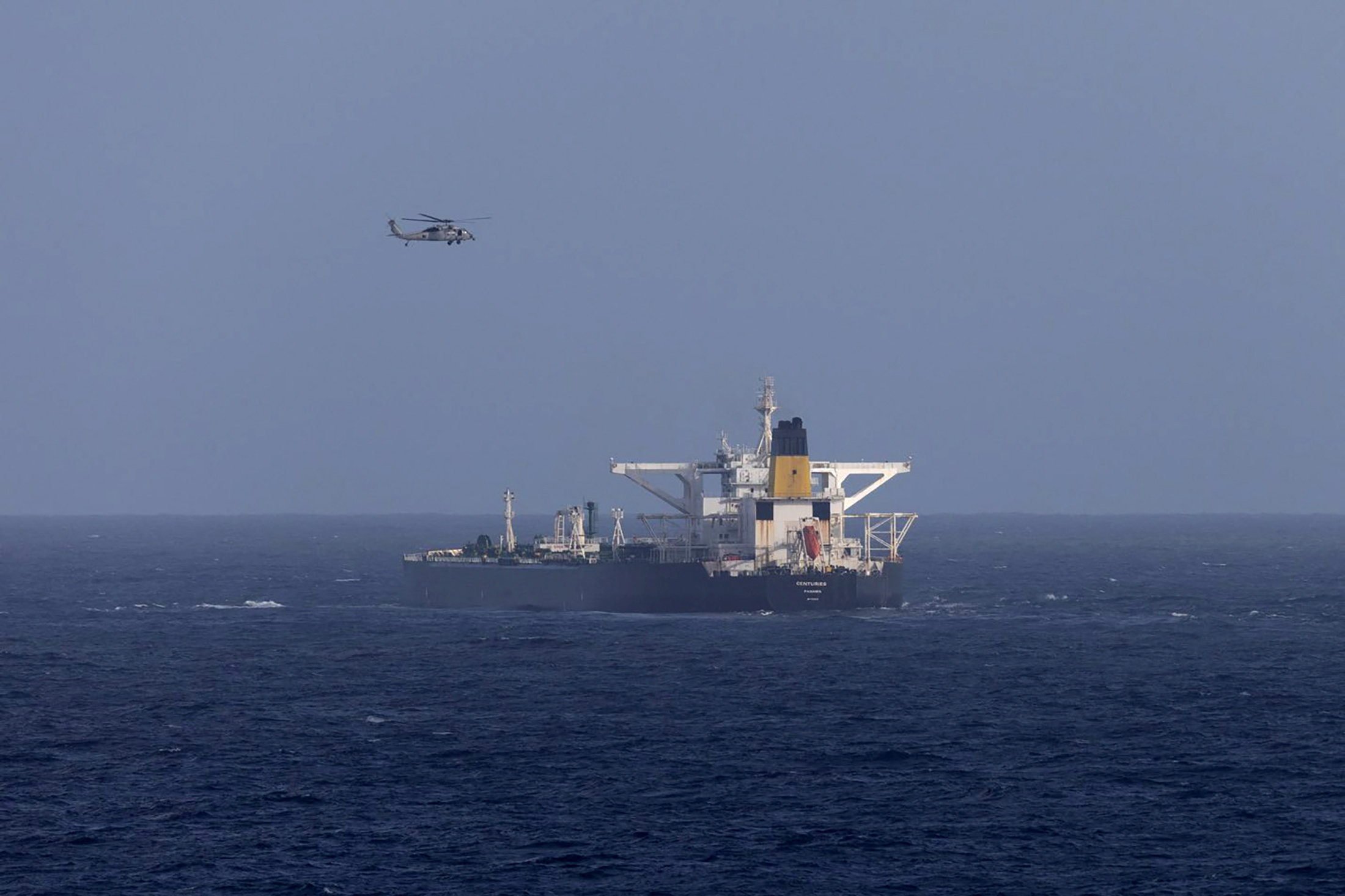 A US military helicopter flies over the Panama-flagged Centuries, which was intercepted by the US Coast Guard on Saturday. On Sunday, officials said the US was pursuing a third tanker in waters off Venezuela. Photo: DHS / Handout via Reuters
