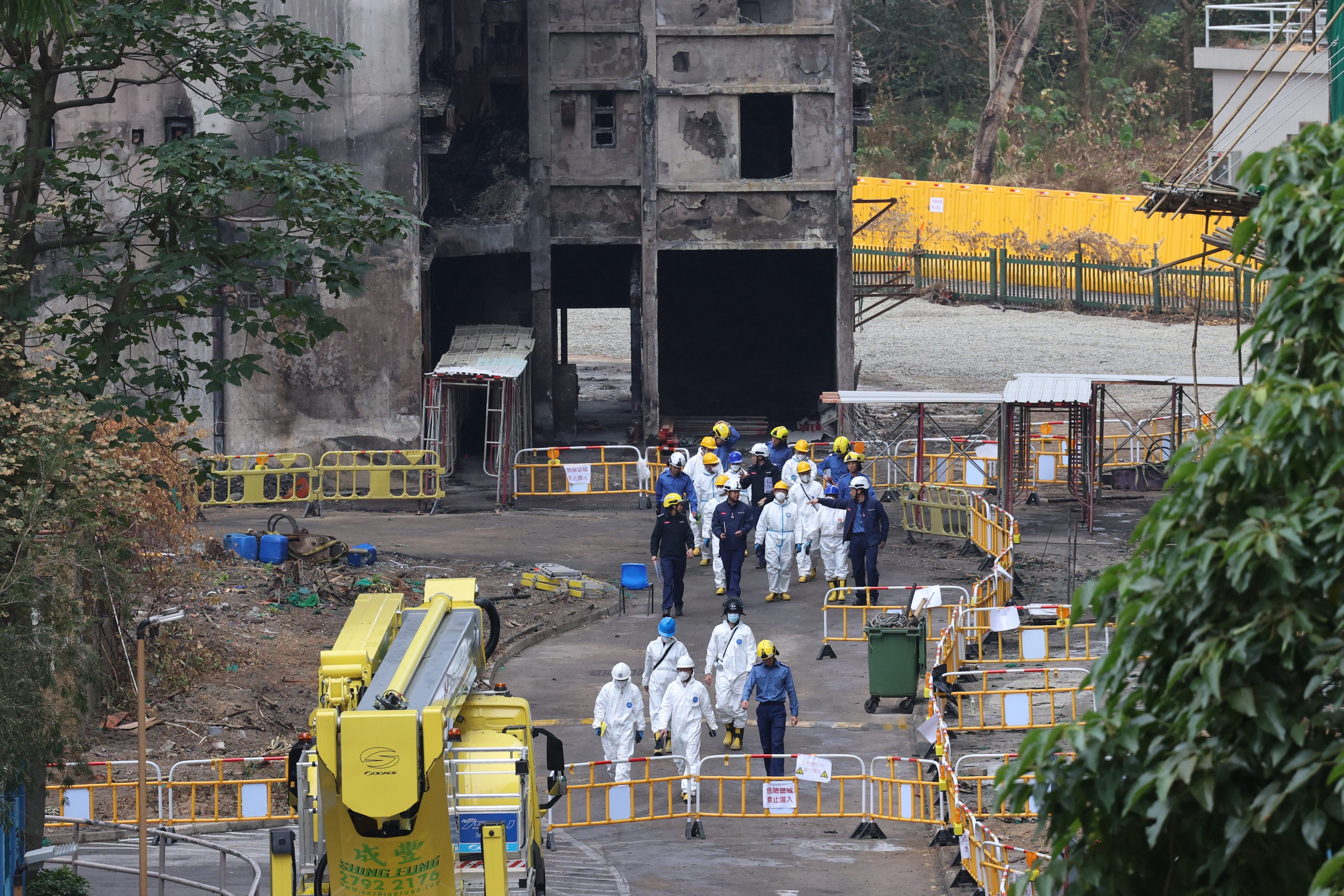 Members of the independent committee inspect Wang Fuk Court in the company of firefighters. Photo: Jelly Tse