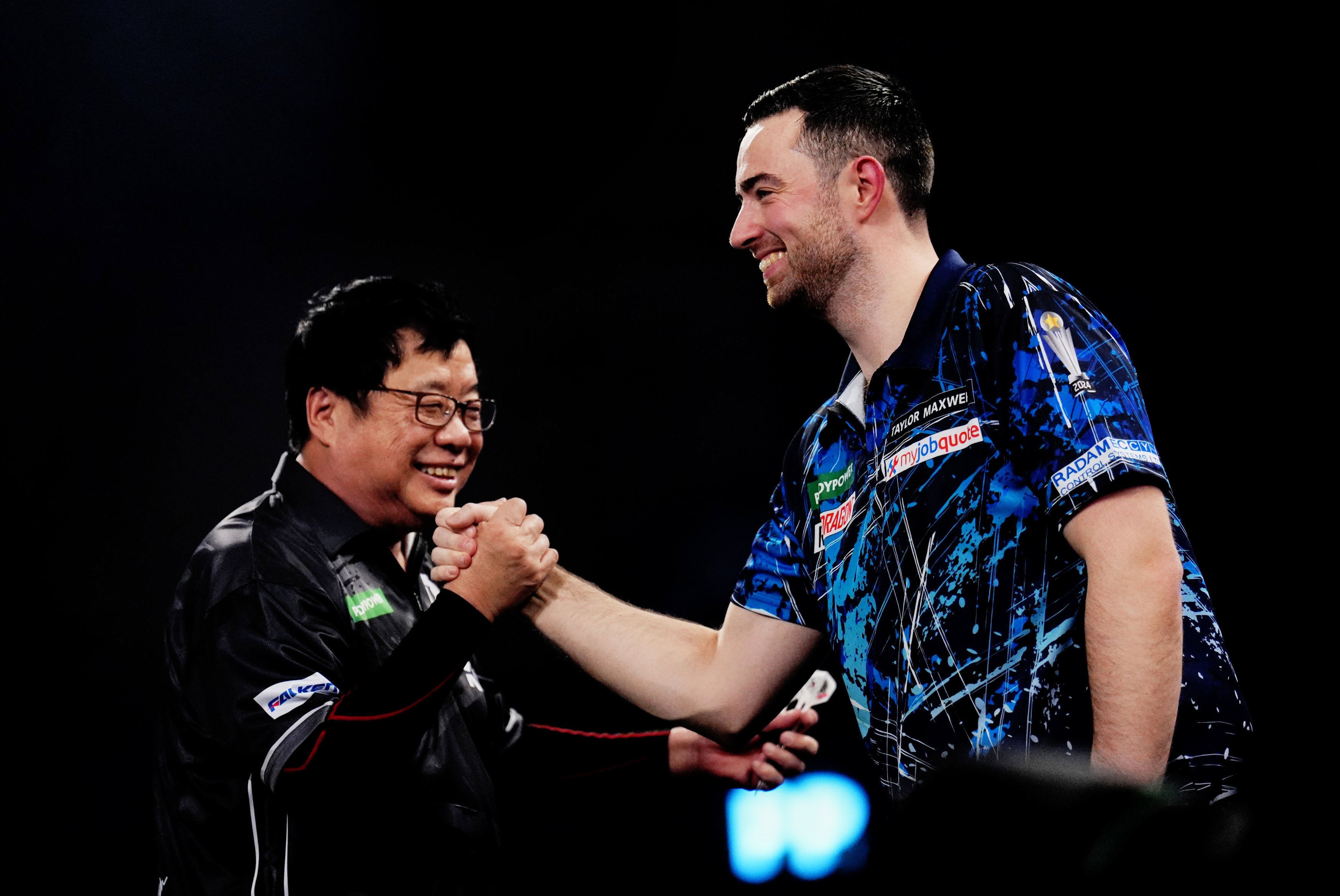 Paul Lim shakes hands with Luke Humphries after winning a leg of their World Darts Championship clash at the Alexandra Palace. Photo: AP