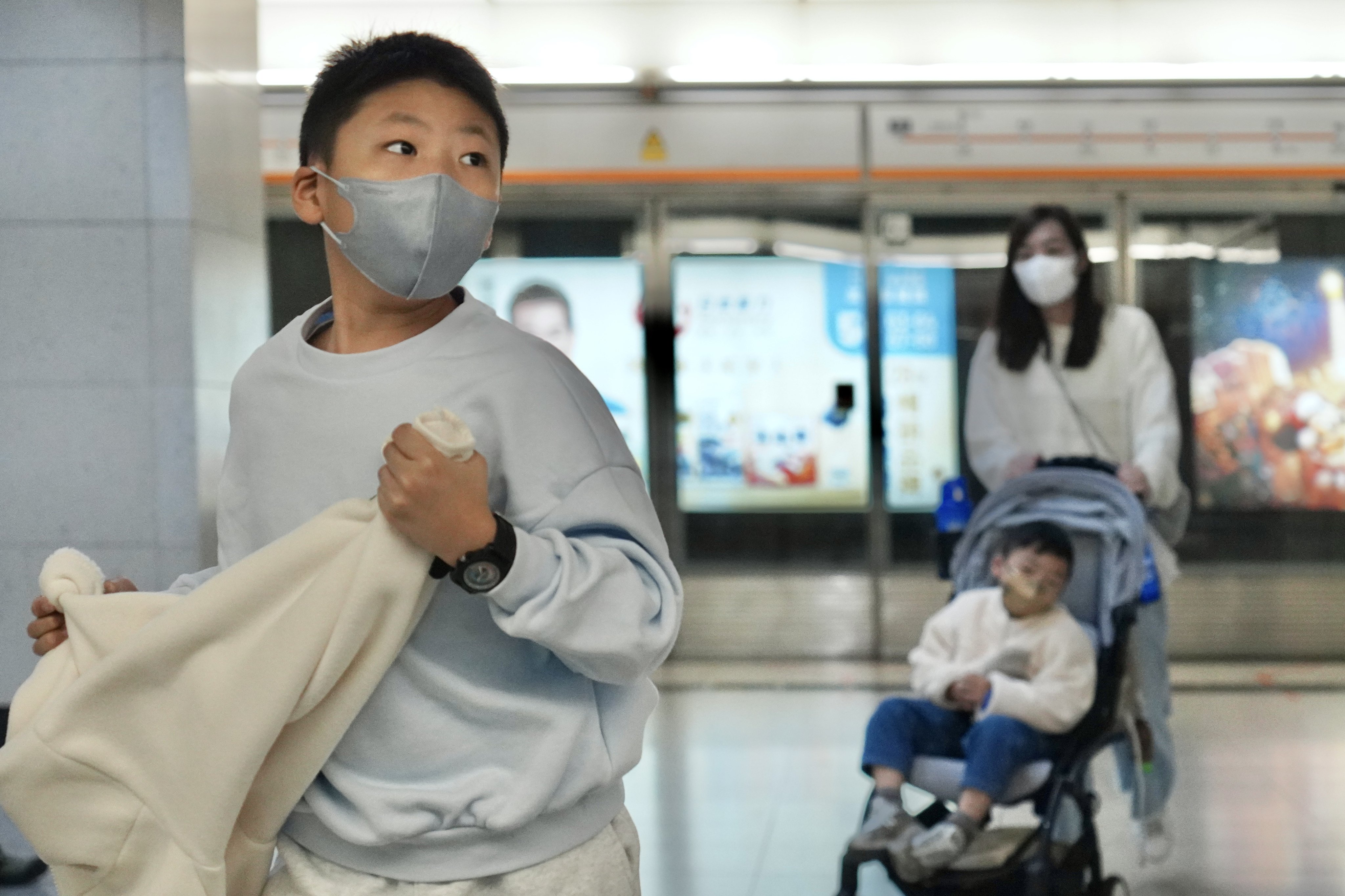 A boy and his family wear masks in an MTR station to protect themselves against seasonal flu and other infectious diseases. Photo: Karma Lo