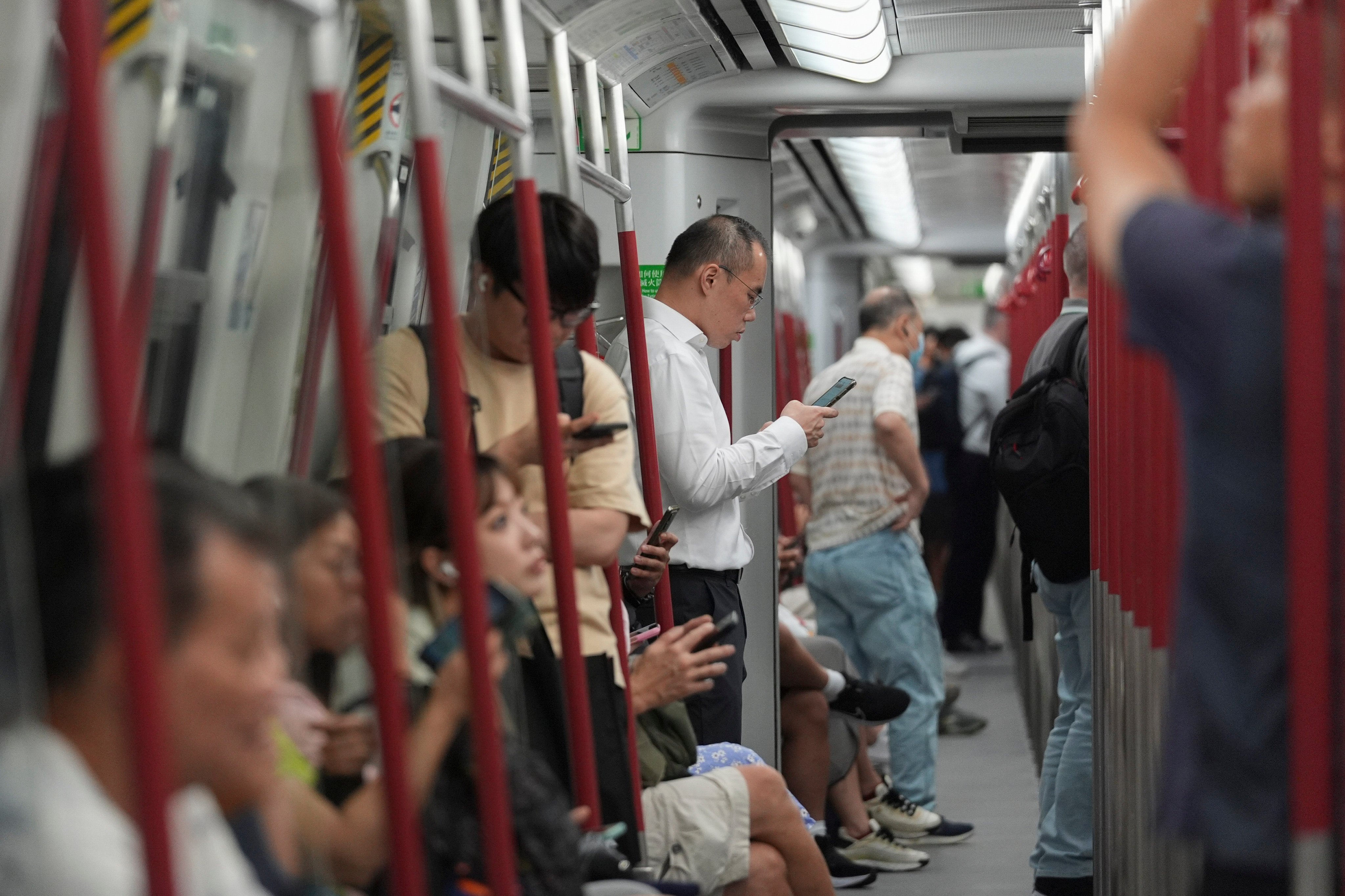 Hongkongers engrossed in their phones are a common sight on the MTR. Photo: Eugene Lee
