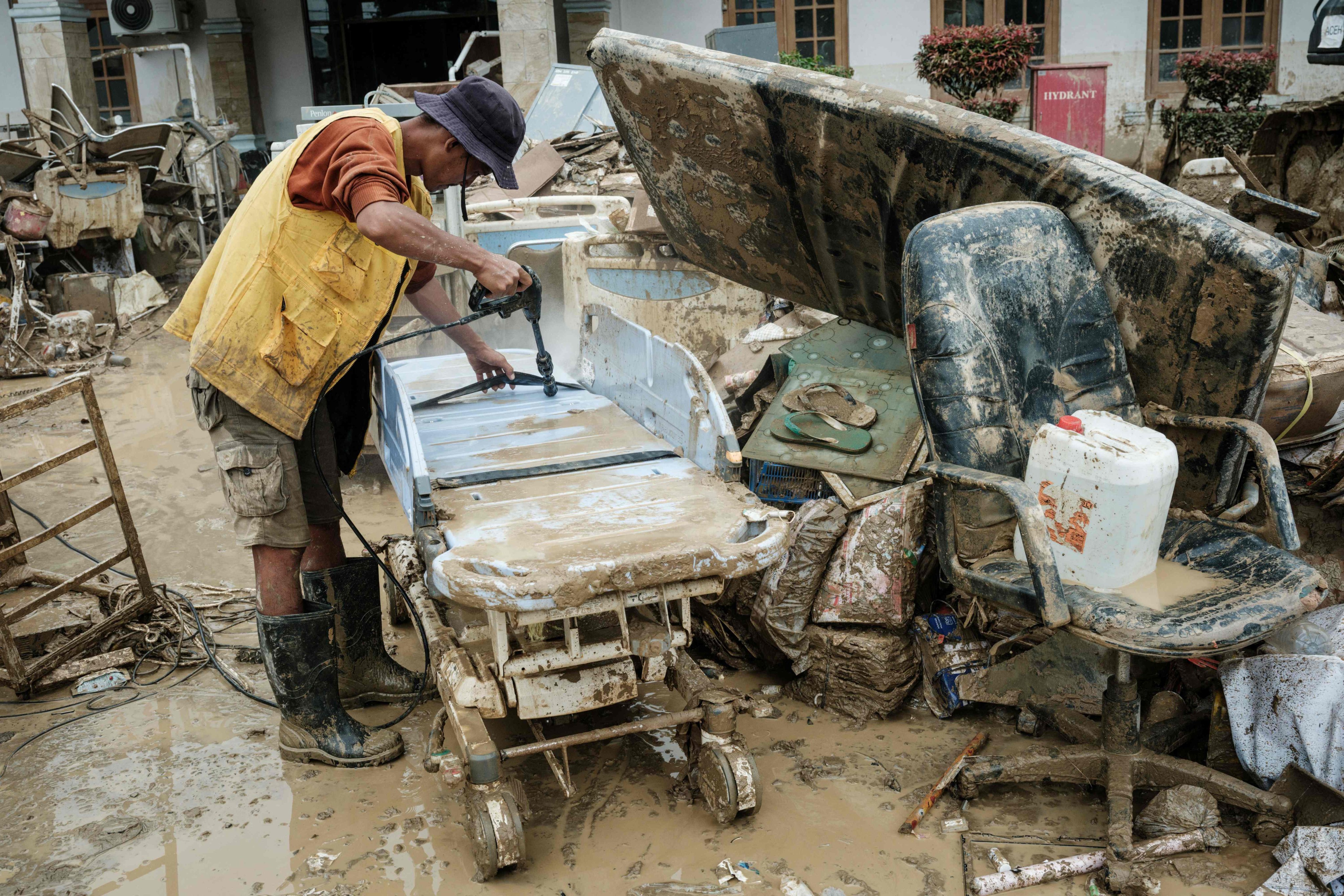 A staff member works to clean a submerged medical equipment after a flash flood at a hospital in Aceh Tamiang, northern Sumatra, on December 16. Photo: AFP