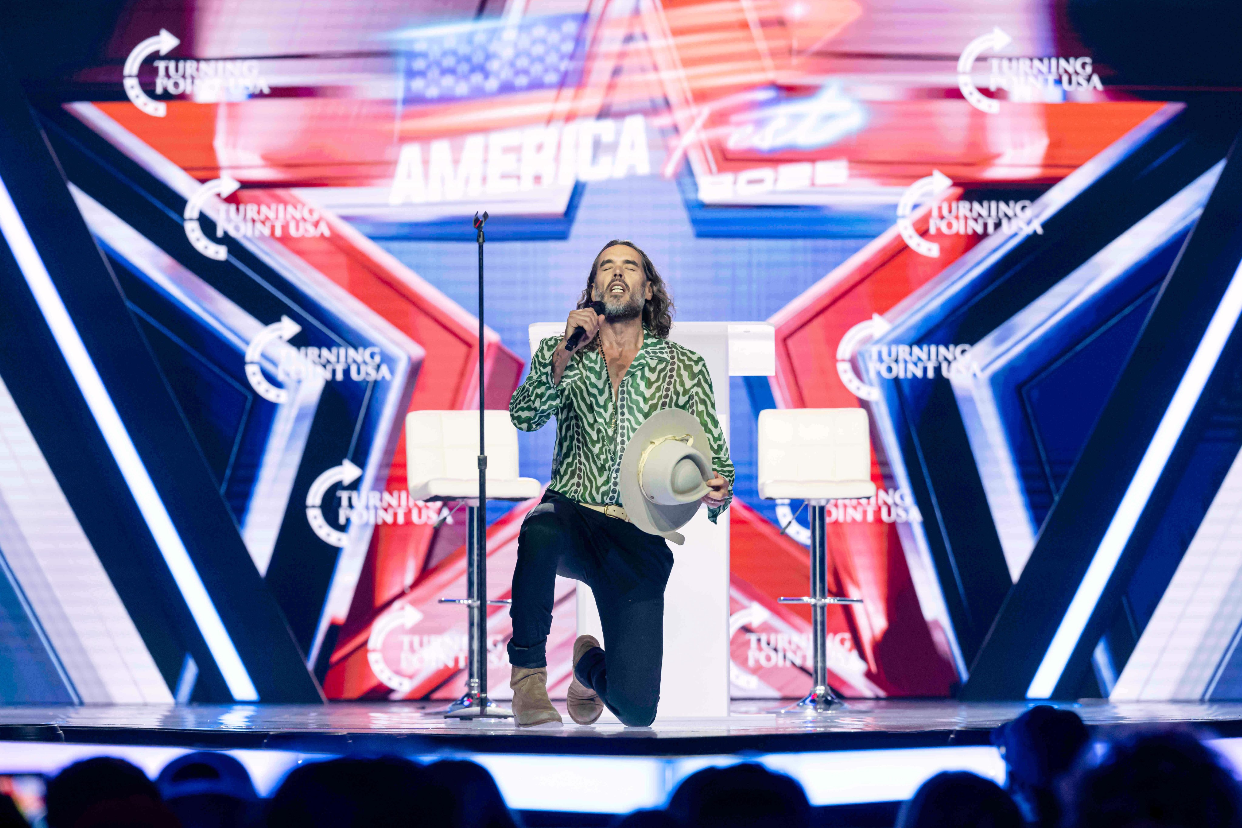 Russell Brand speaking at Turning Point USA’s AmericaFest 2025, on December 18 in Phoenix. Photo: AP