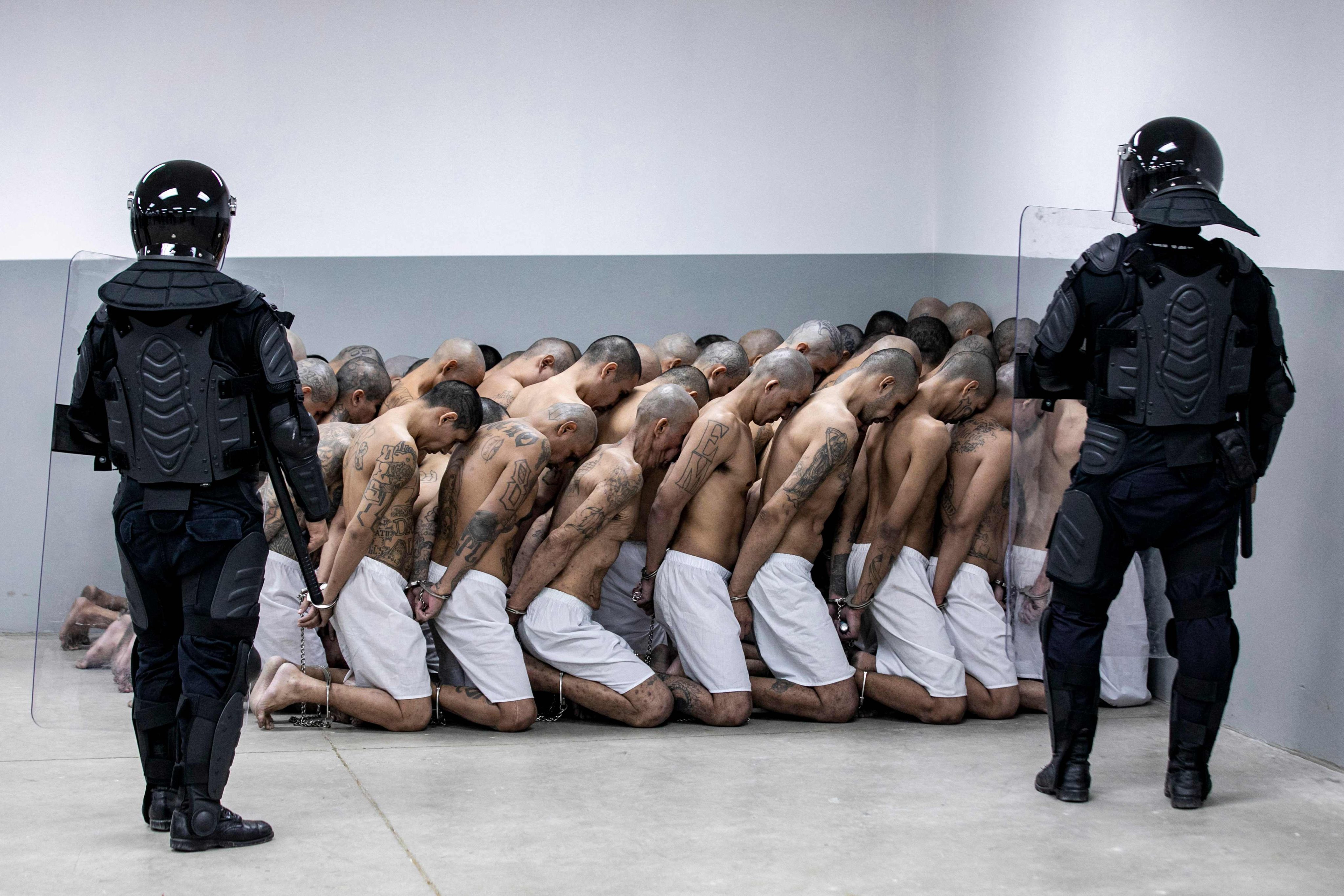 Police officers keep watch on new inmates at the CECOT facility in Tecoluca, El Salvador, in March 2023. Photo: El Salvador Presidency Press Office via AFP