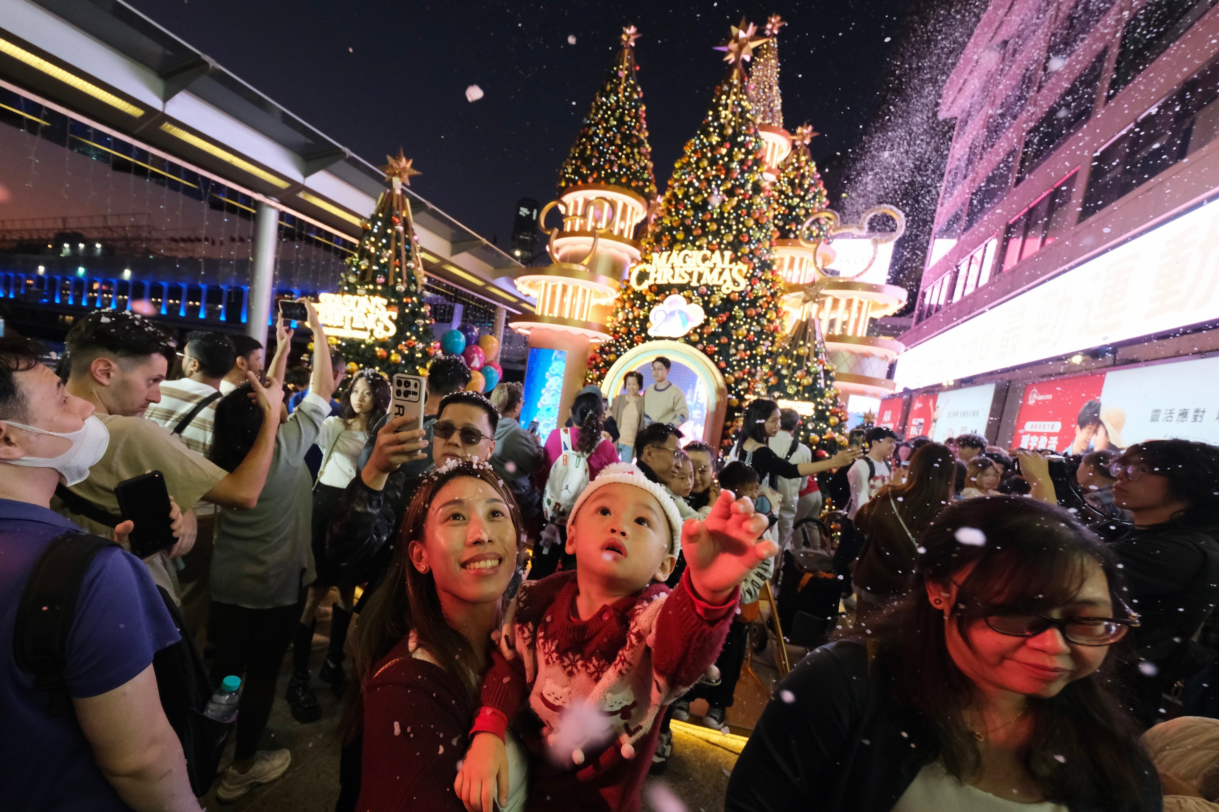 People gather along the Tsim Sha Tsui waterfront to take in the Christmas Eve sights. Photo: Karma Lo