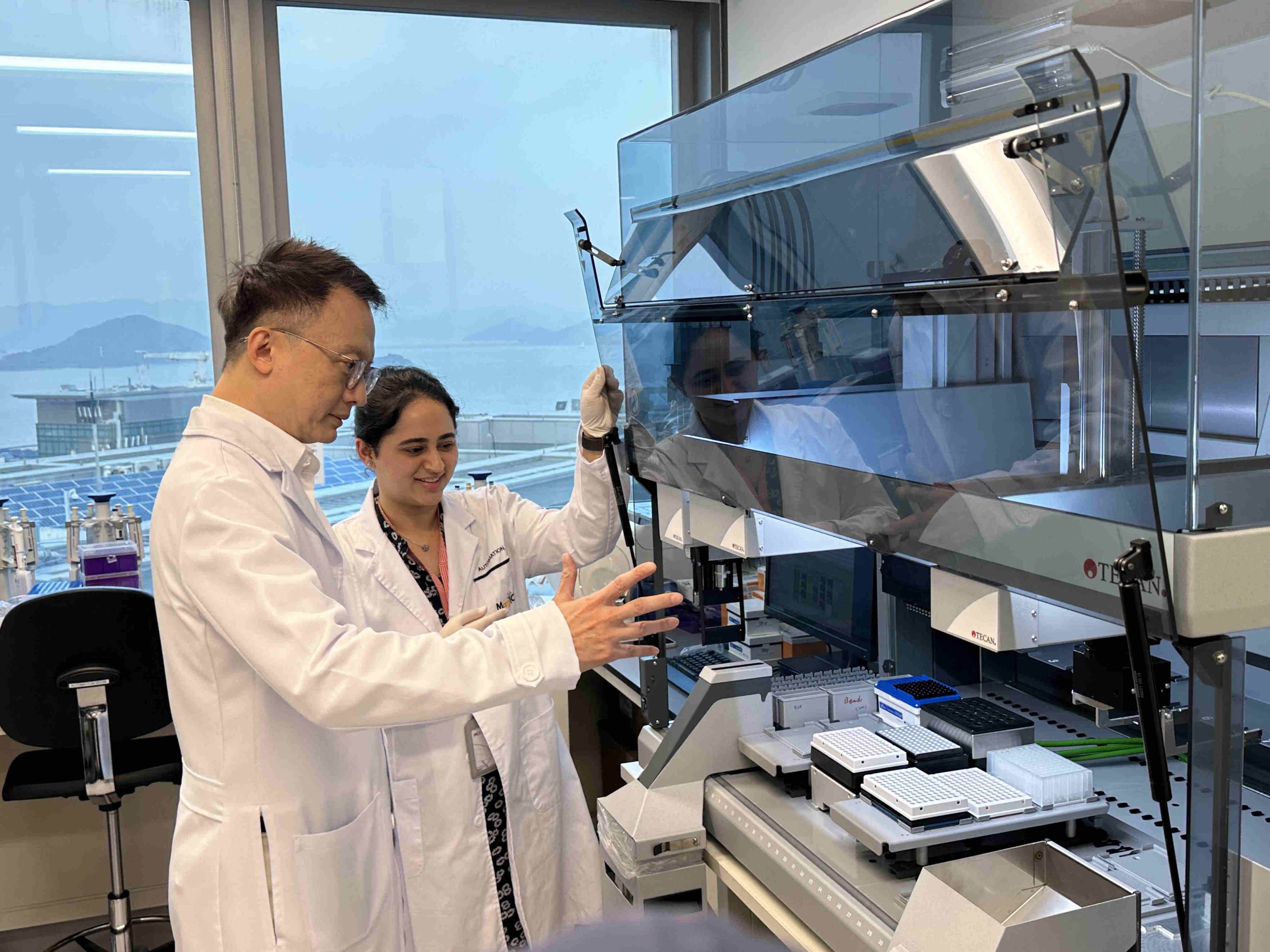 Professor Francis Chan (left) and the lab assistant demonstrate the new screening system. Photo: Fiona Chow