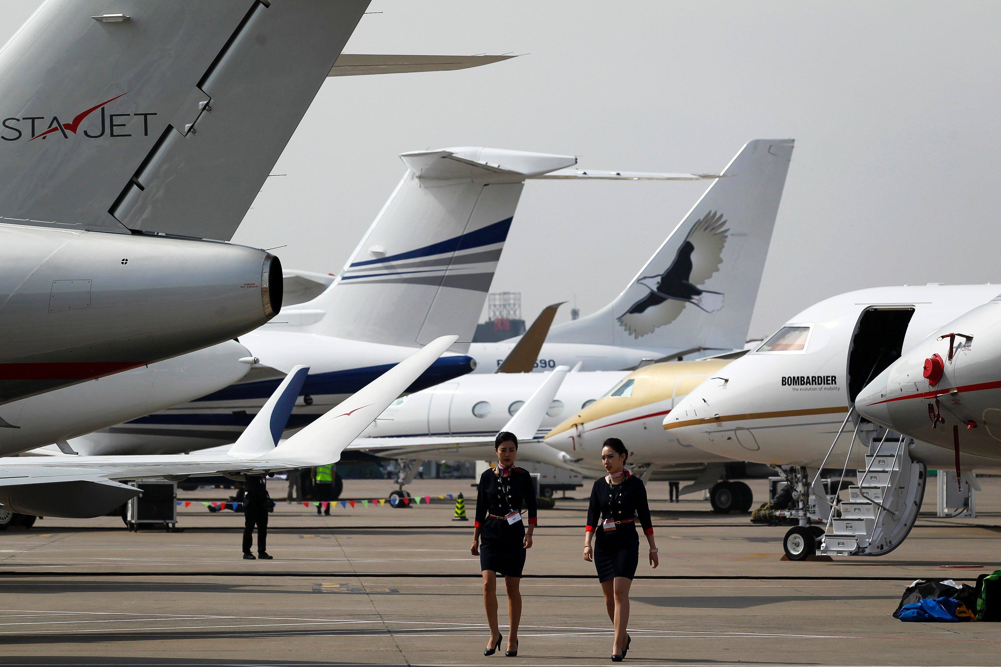Two crew members walk past business jets in Shanghai. Photo: AFP