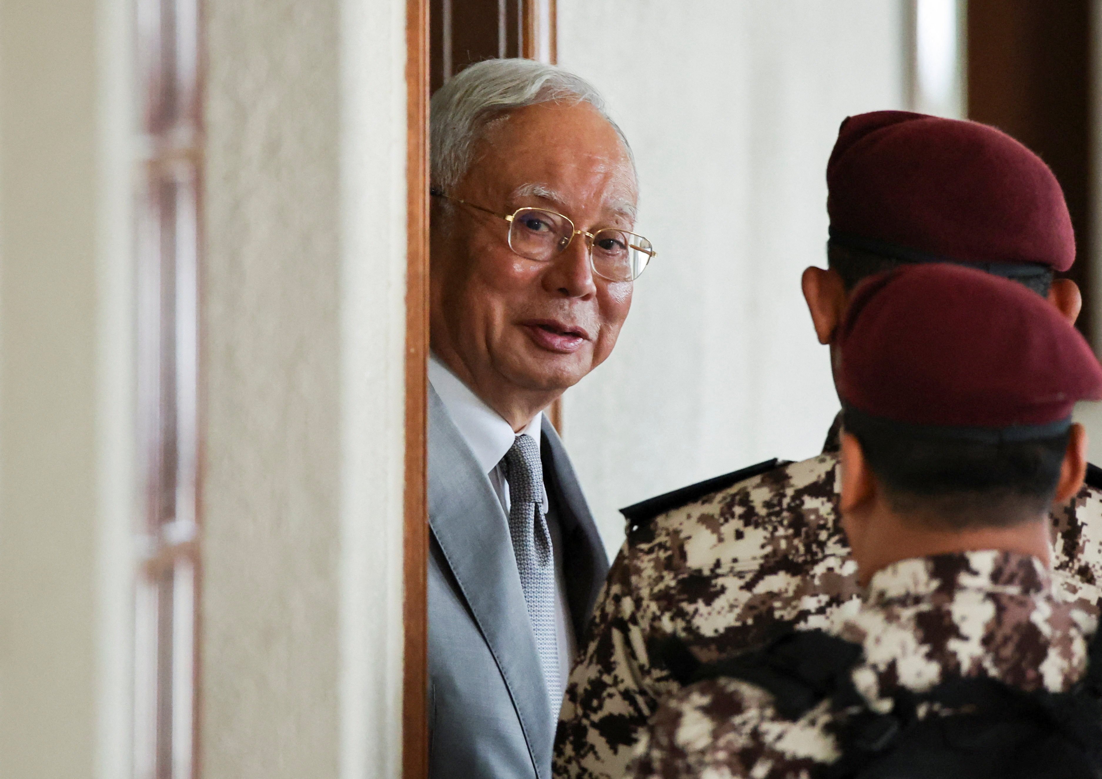 Malaysia’s former prime minister Najib Razak is escorted by prison guards at the Kuala Lumpur Court complex on Monday. Photo: Reuters