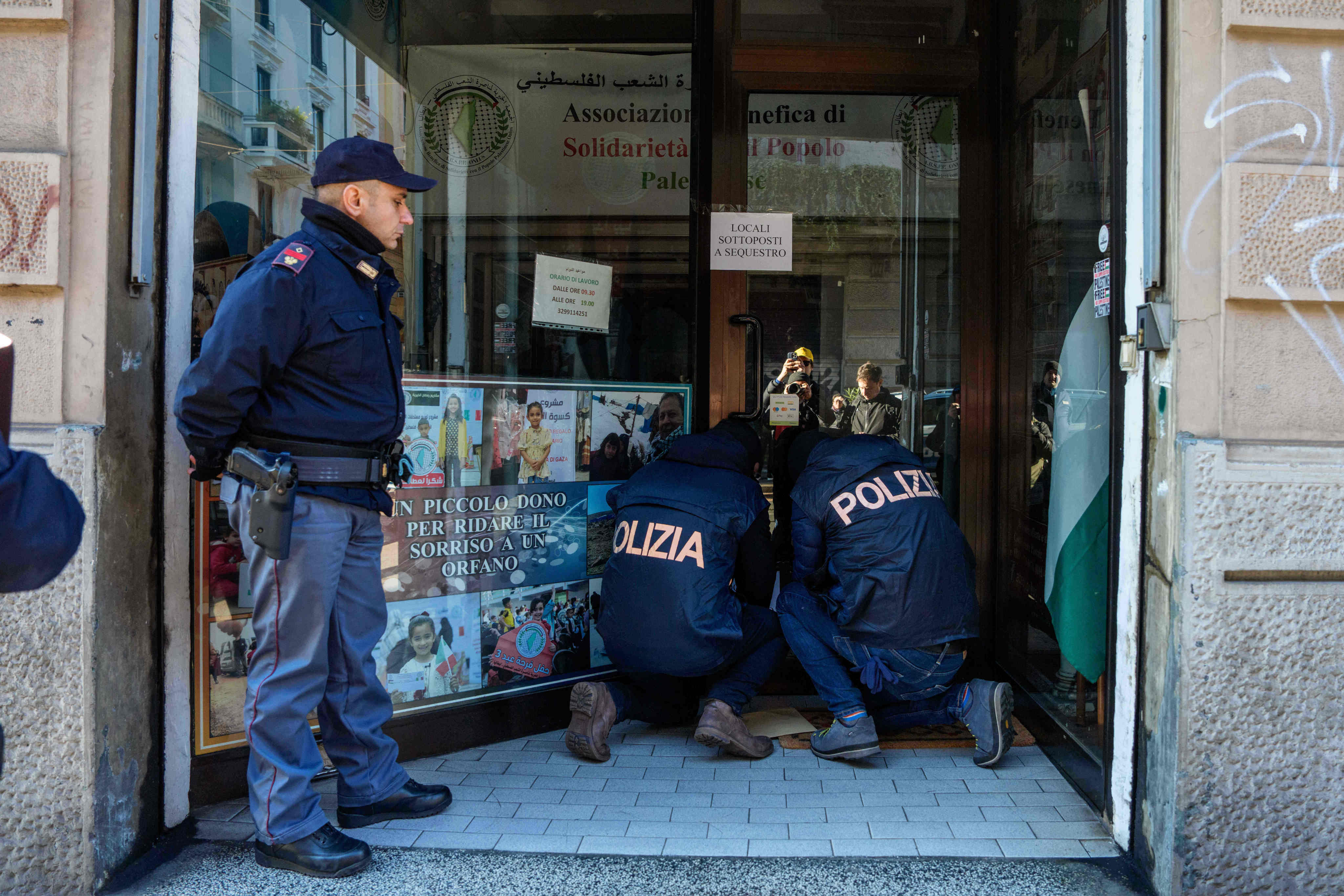 Police officers inspect a charity for Palestinian civilians in Milan on Saturday. Photo: LaPresse/AP