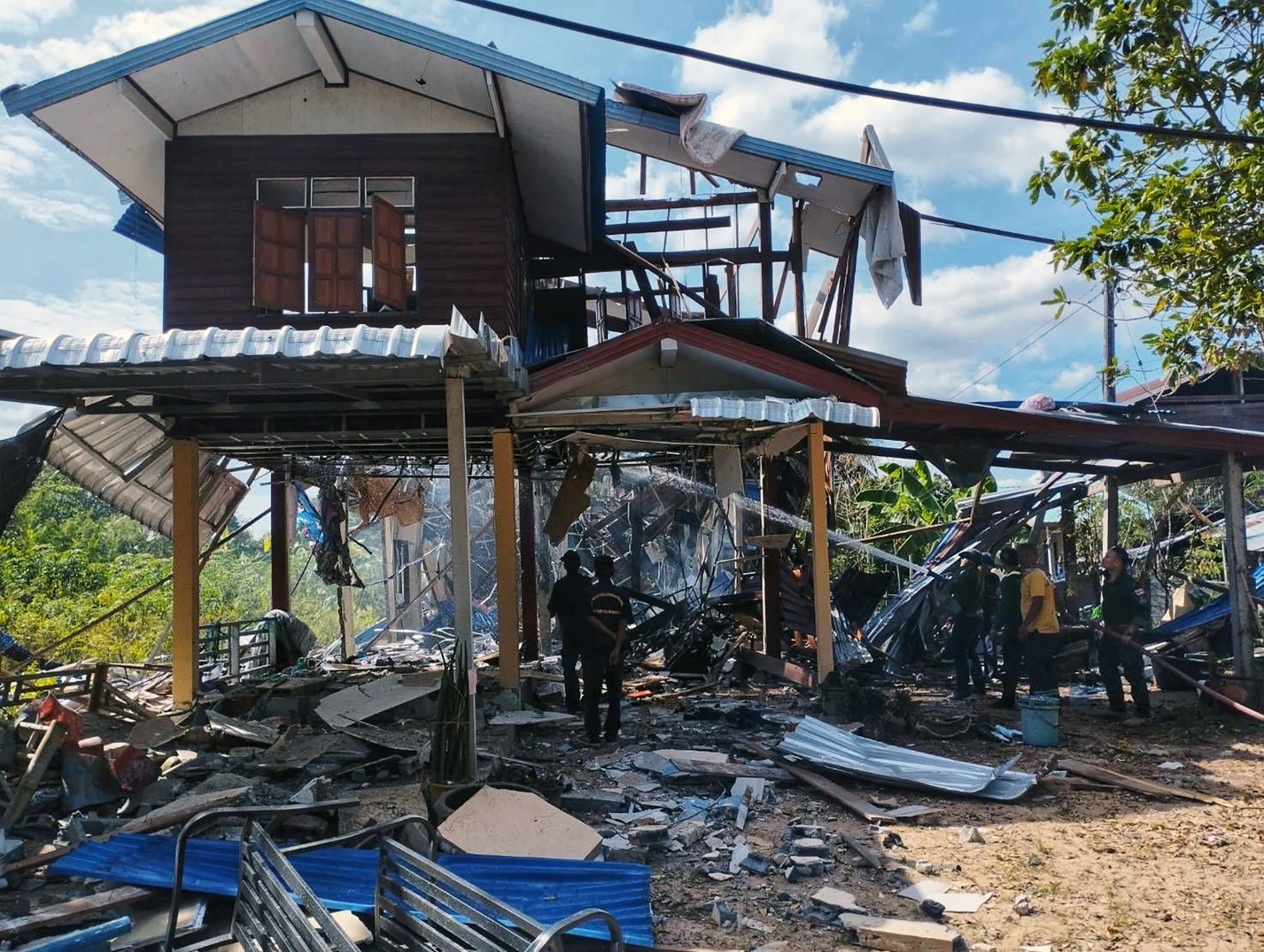 Rescue workers extinguishing a fire at a house after it was hit by Cambodian rocket strikes during clashes between Thai and Cambodian troops, at a village in Kantharalak district, Si Sa Ket province, Thailand, on December 14. Photo: EPA/Royal Thai Army