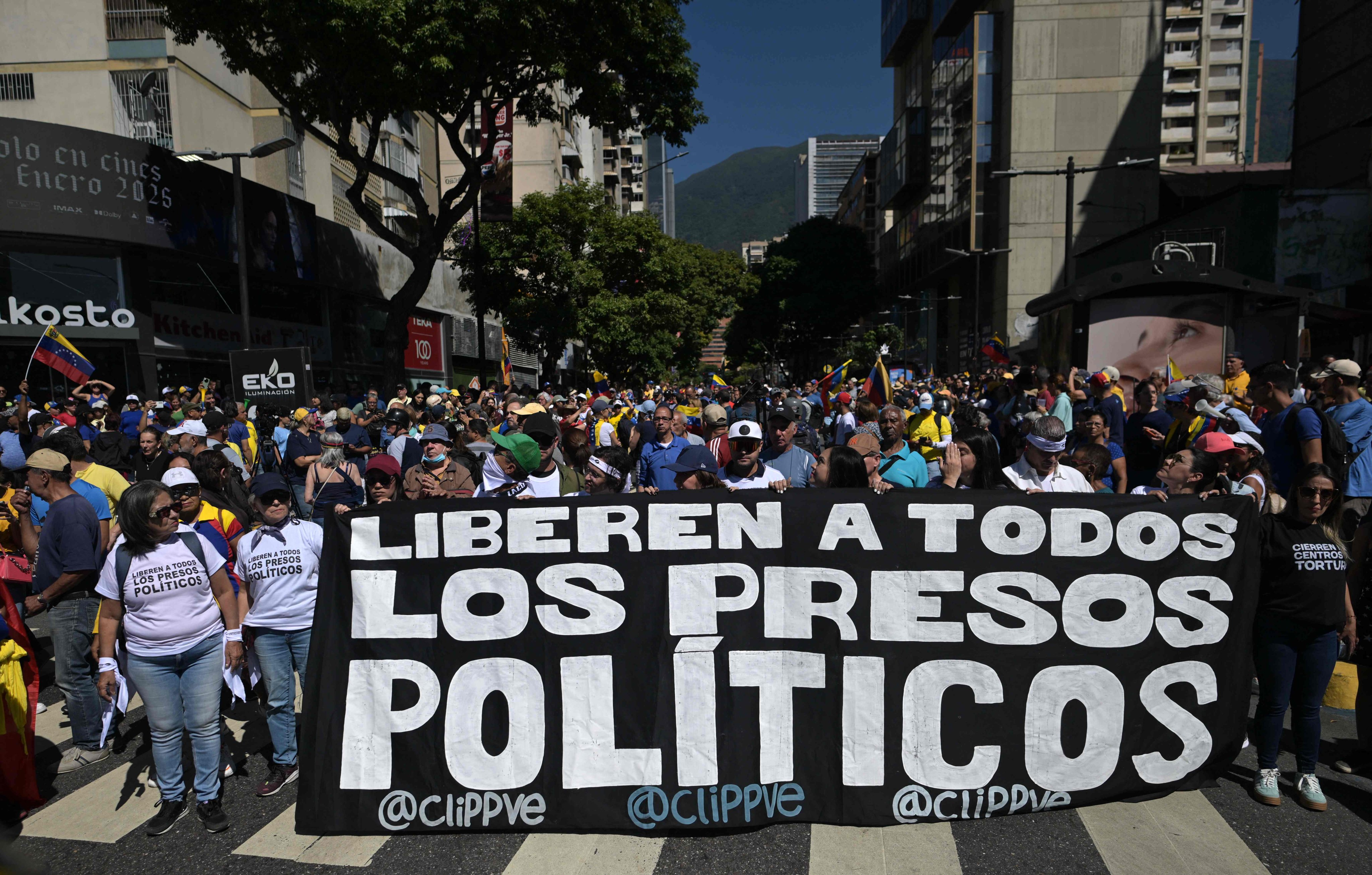 Demonstrators hold a banner demanding the release of all political prisoners during a protest in Caracas, Venezuela on January 9. On Friday, the prisons authority said it had released 99 prisoners. Photo: AFP
