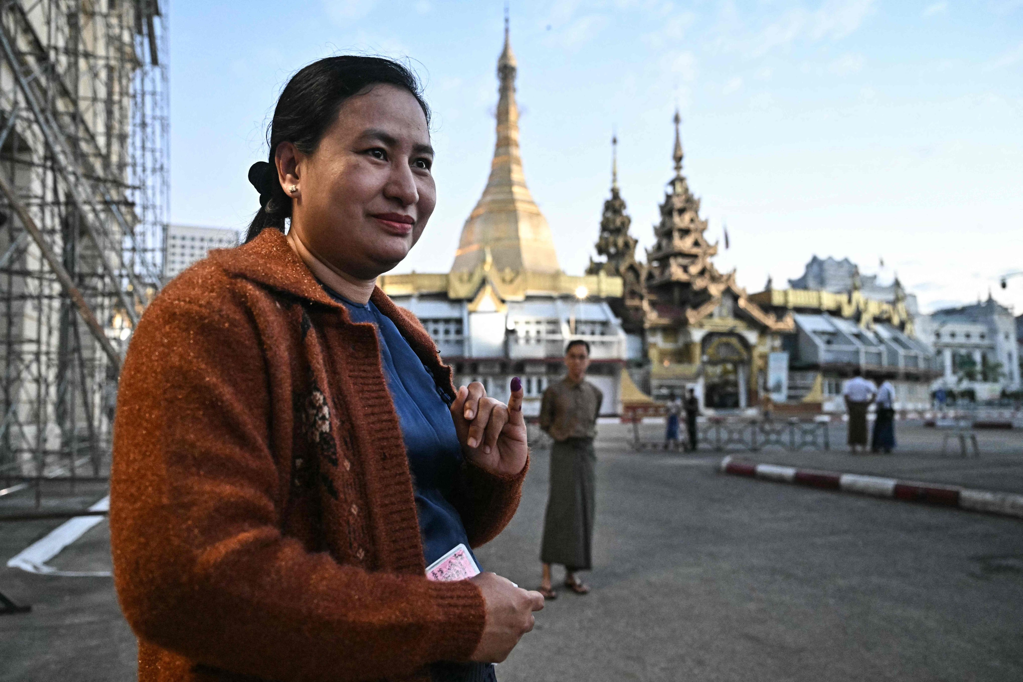 A woman shows her inked finger after voting at a polling station during the first phase of Myanmar’s general election in Yangon on Sunday. Photo: AFP