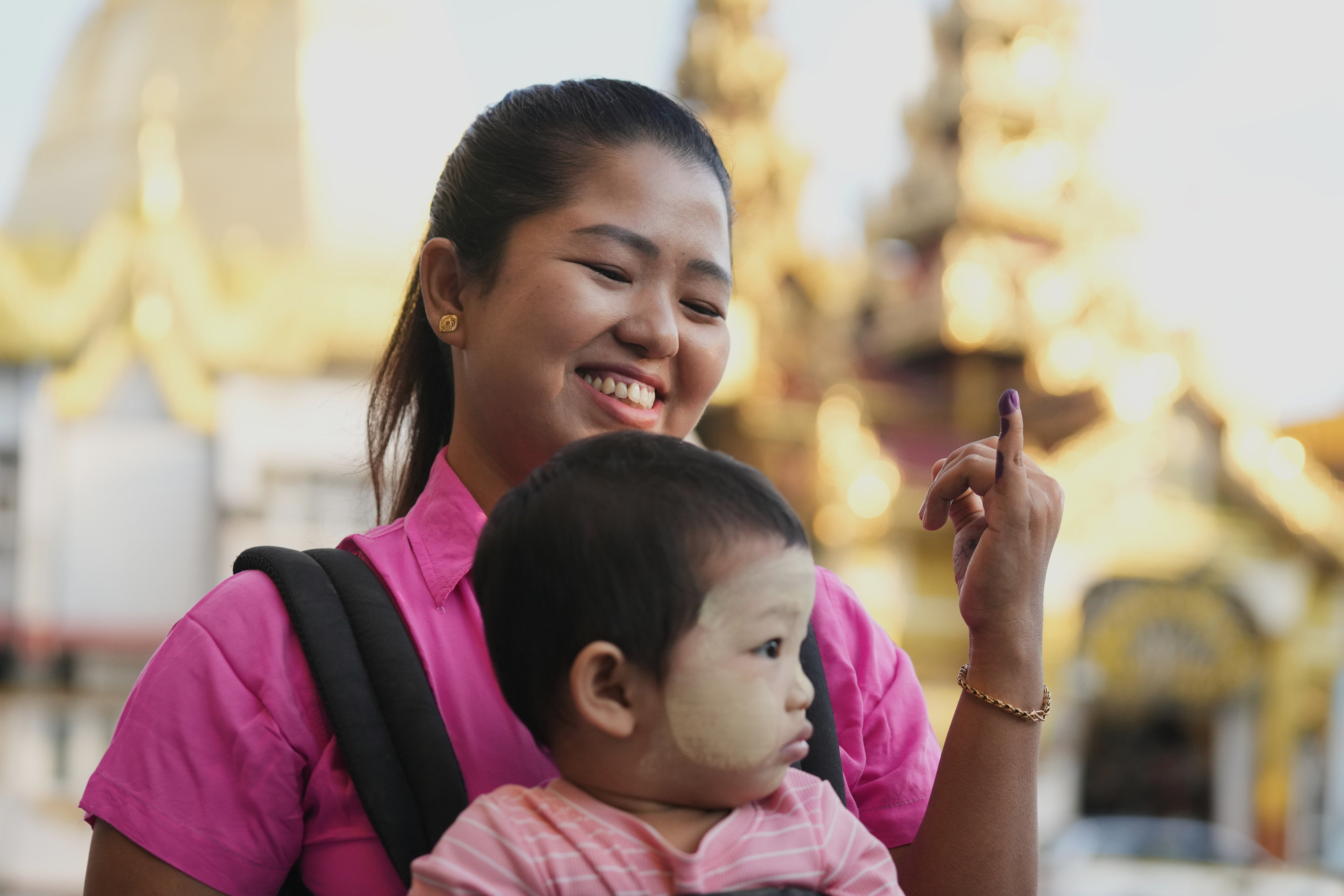 A voter shows her inked finger as she leaves a polling station in Yangon, Myanmar, on Sunday. Photo: AP