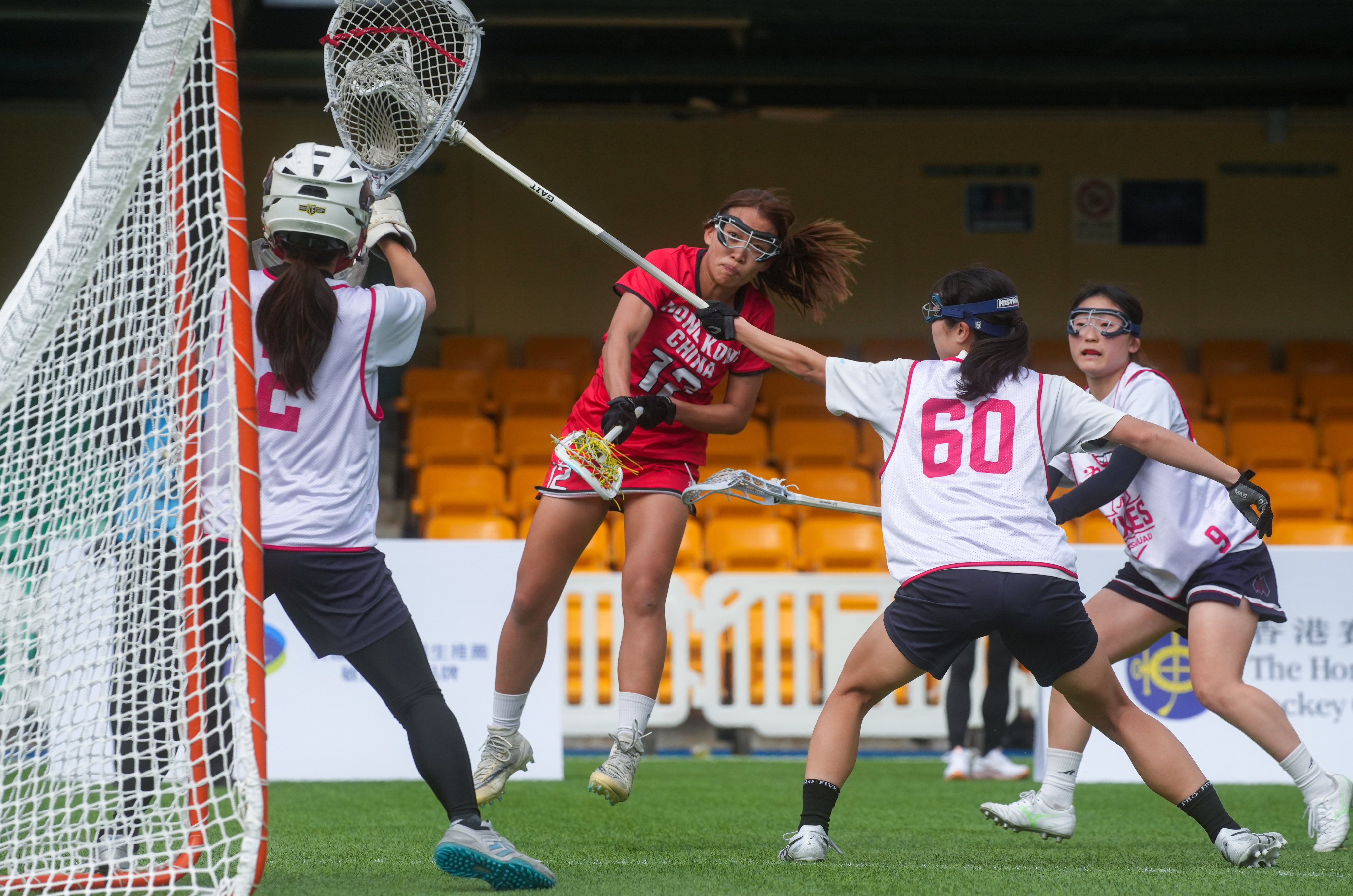 Hong Kong’s Hon Cheunk-yee takes a shot under pressure from JLA’s Korogi Riho (right) during the women’s bronze medal match at the Hong Kong International Lacrosse Sixes. Photo: Sun Yeung