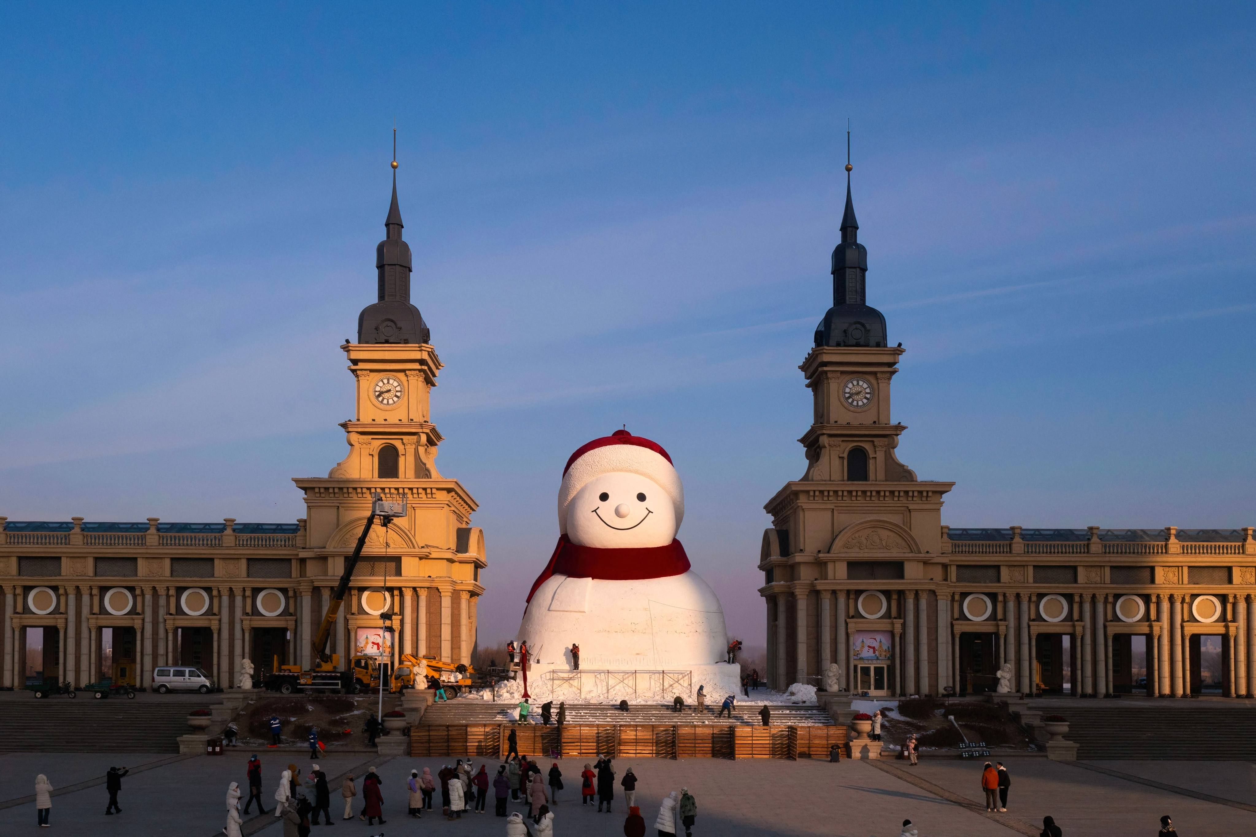 Workers put the finishing touches on a giant snowman sculpture at Qunli Music Park in Harbin on December 15, 2025. Photo: AFP
