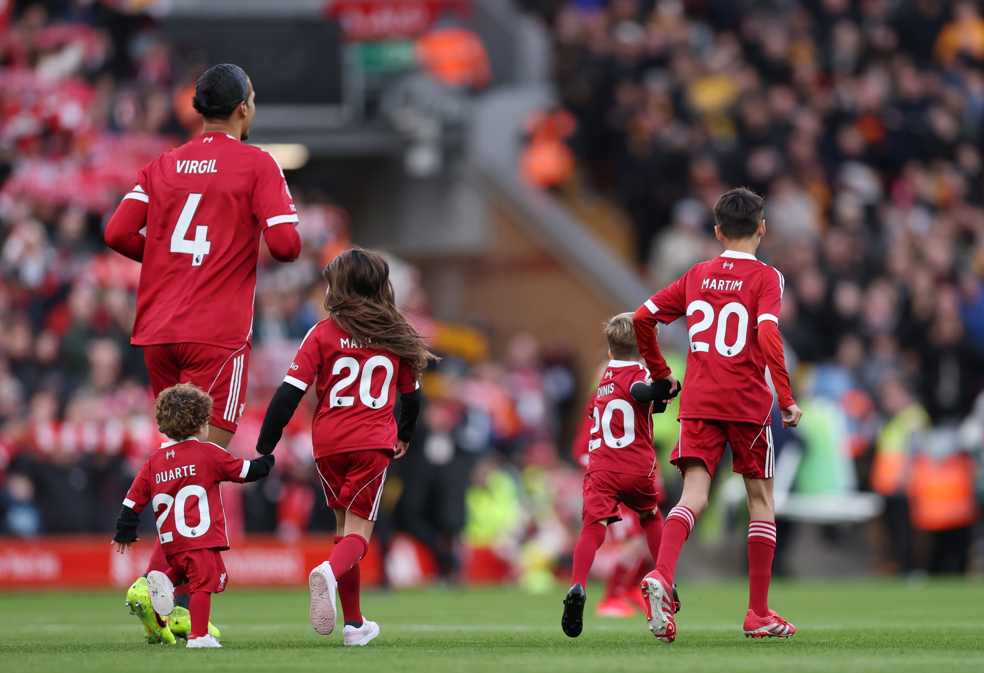 Two Diogo Jota’s children, Dinis (right) and Duarte (left) walk onto the pitch with Virgil van Dijk of Liverpool ahead of the Premier League match between Liverpool and Wolverhampton Wanderers on December 27. Photo: EPA