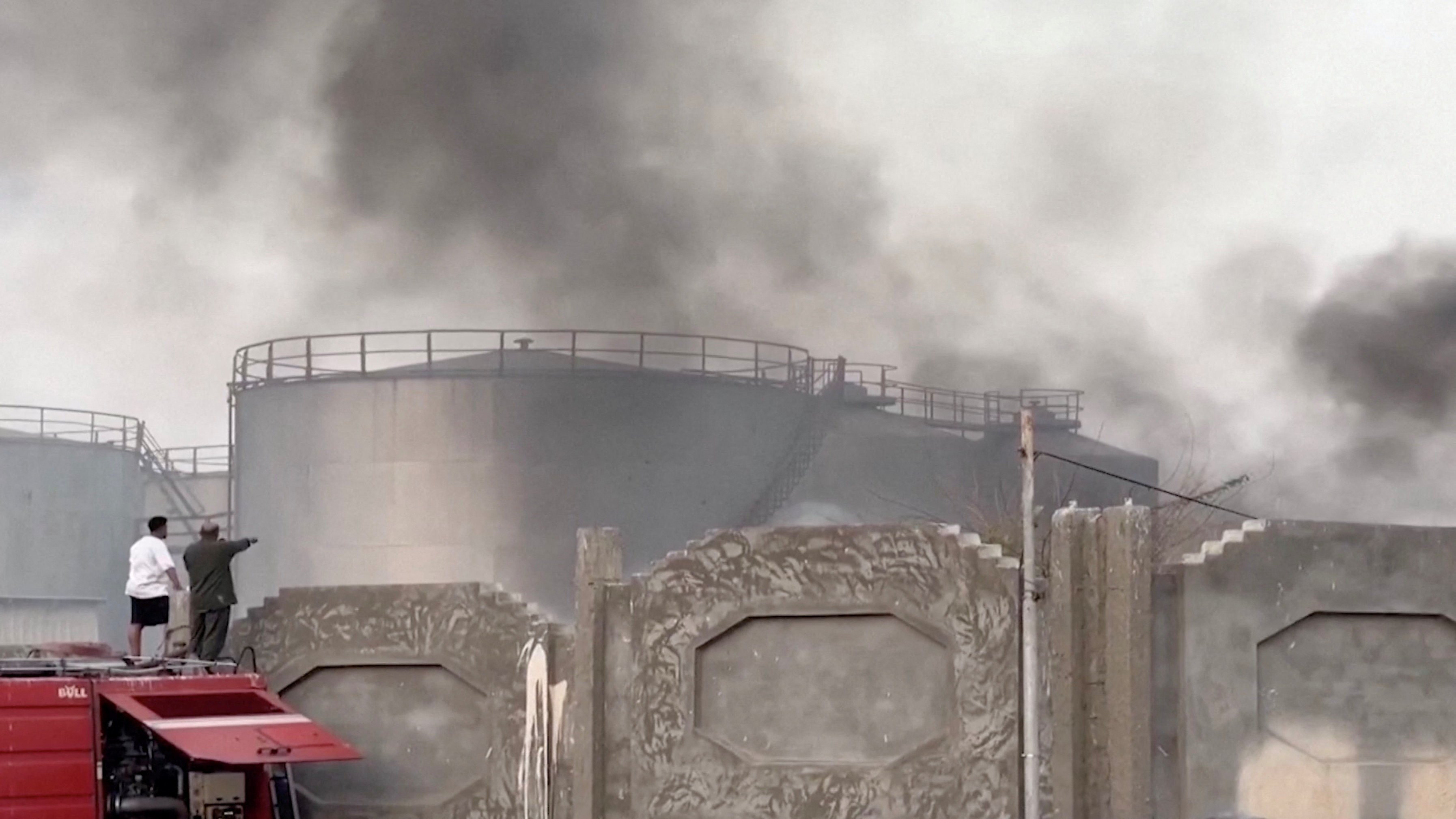 A video screengrab show a person gesture toward smoke after a Saudi-led airstrike on Tuesday targeting UAE-backed separatists in Mukalla, Yemen. Photo:.Aden al-Mustakillah TV/Reuters