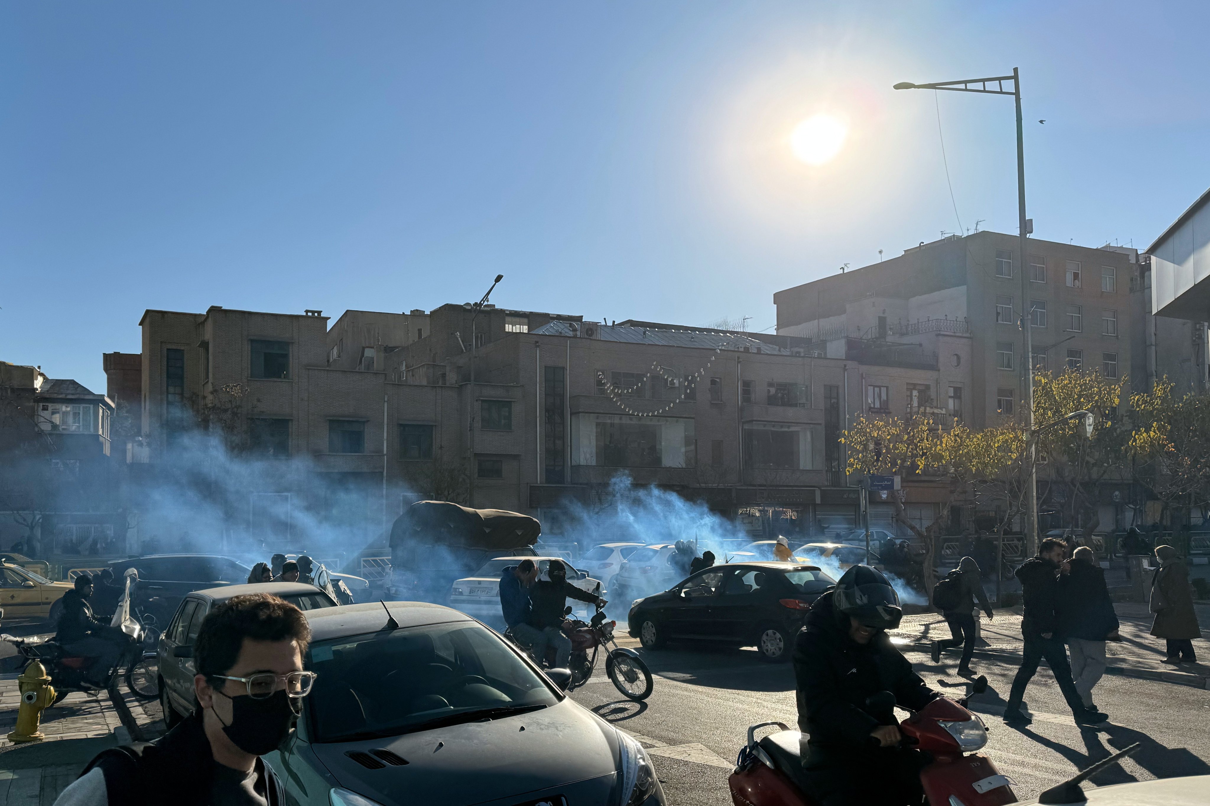 Iranian shopkeepers and traders protest against economic conditions as tear gas is fired by anti-riot police in Tehran, Iran on Monday. Photo: EPA