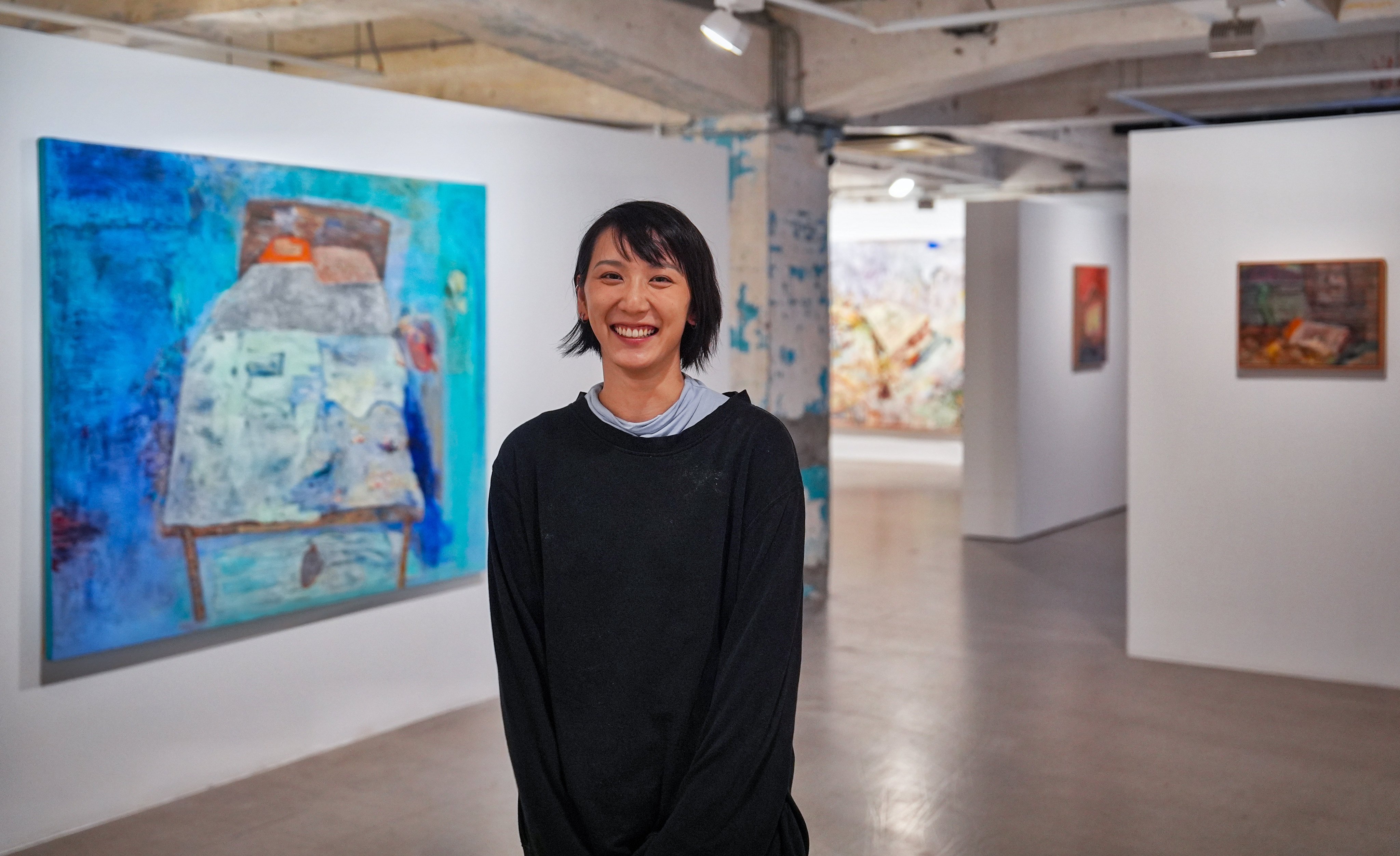 Un Cheng poses among paintings featured in Bedroom Paintings at Blindspot Gallery in Wong Chuk Hang. The Hong Kong artist says her latest solo exhibition is “a visual diary about intimacy”. Photo: Elson Li