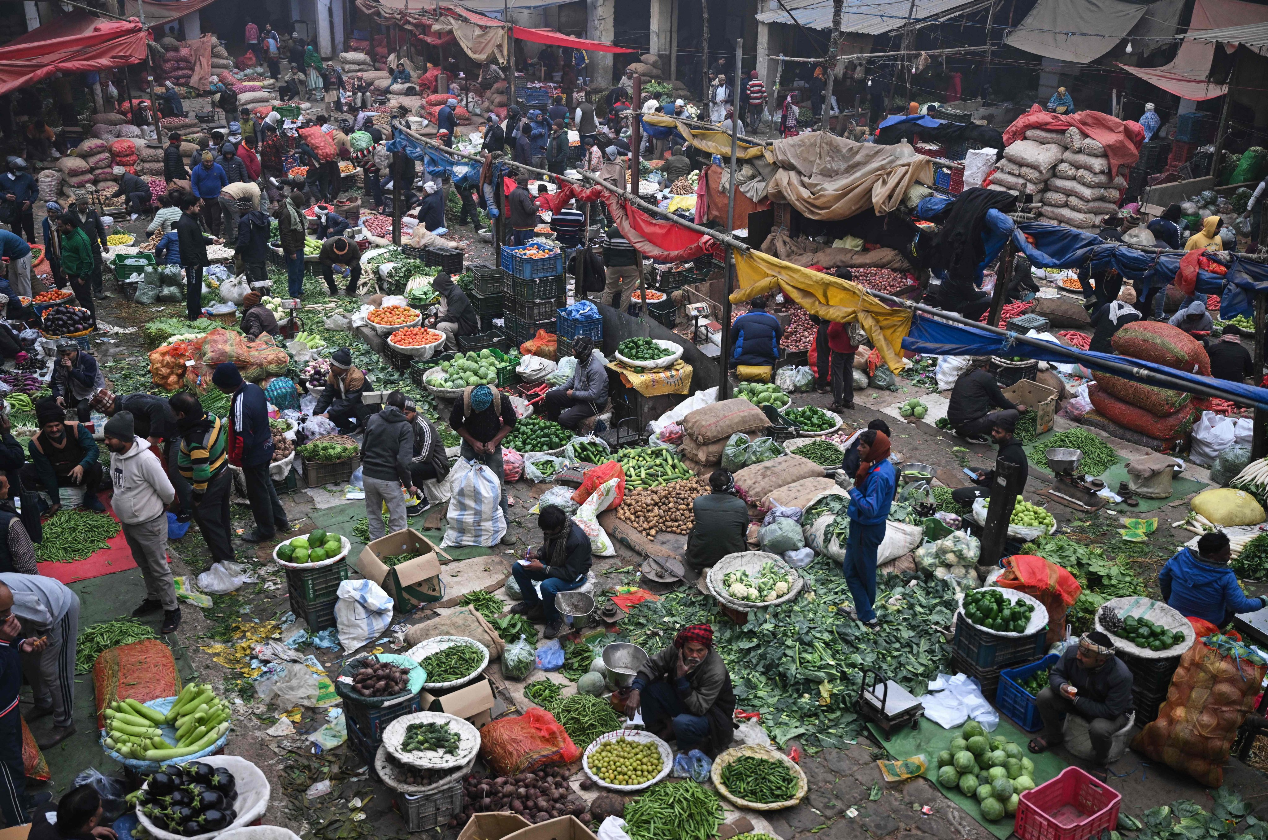 People buy vegetables at a market in the old quarters of New Delhi on Tuesday. Photo: AFP