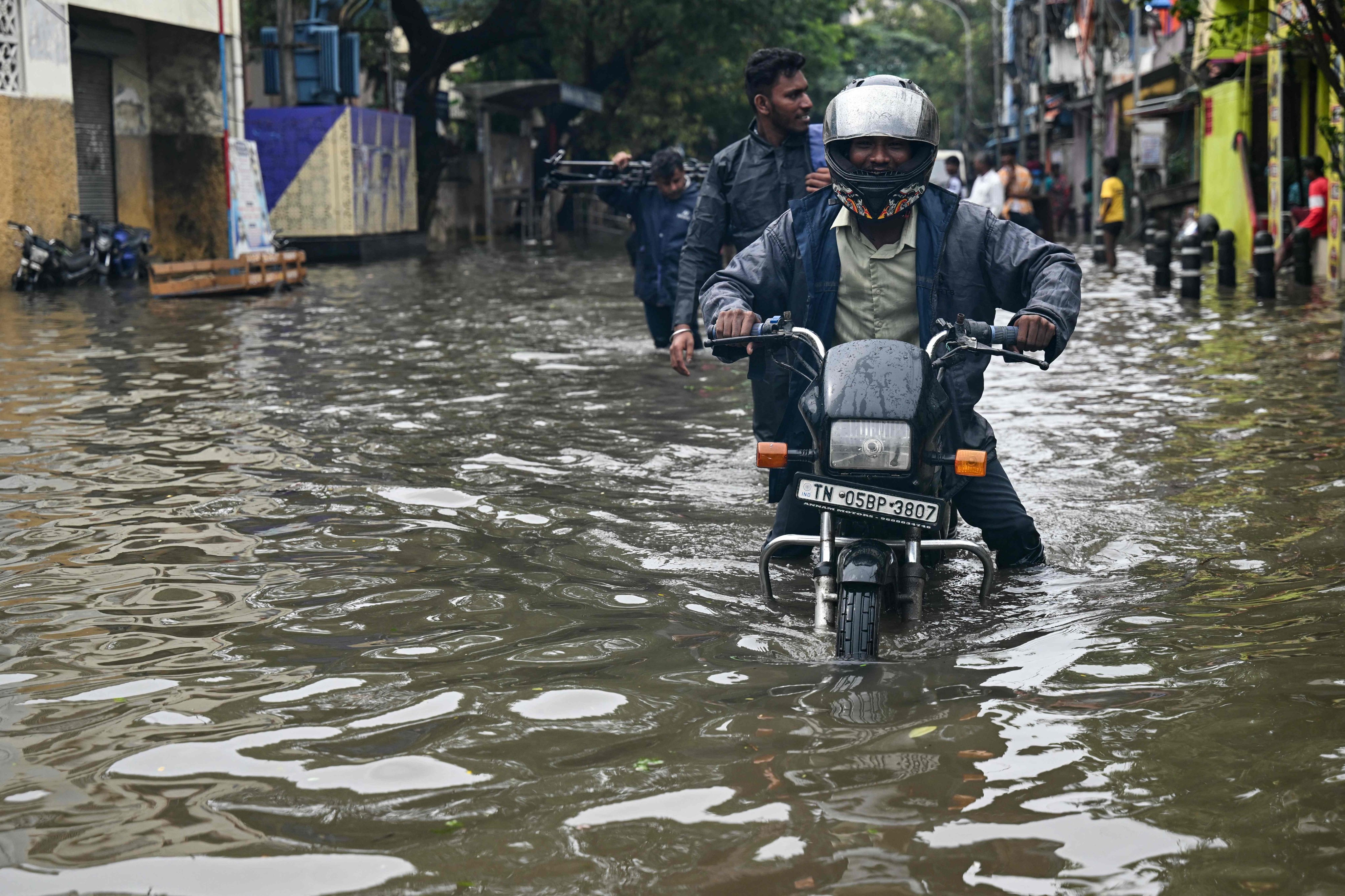 A commuter wades through flood induced by Cyclone Ditwah in Chennai on December 2. A new report showed flooding in India and Pakistan killed more than 1,860 people and cost up to US$6 billion. Photo: AFP