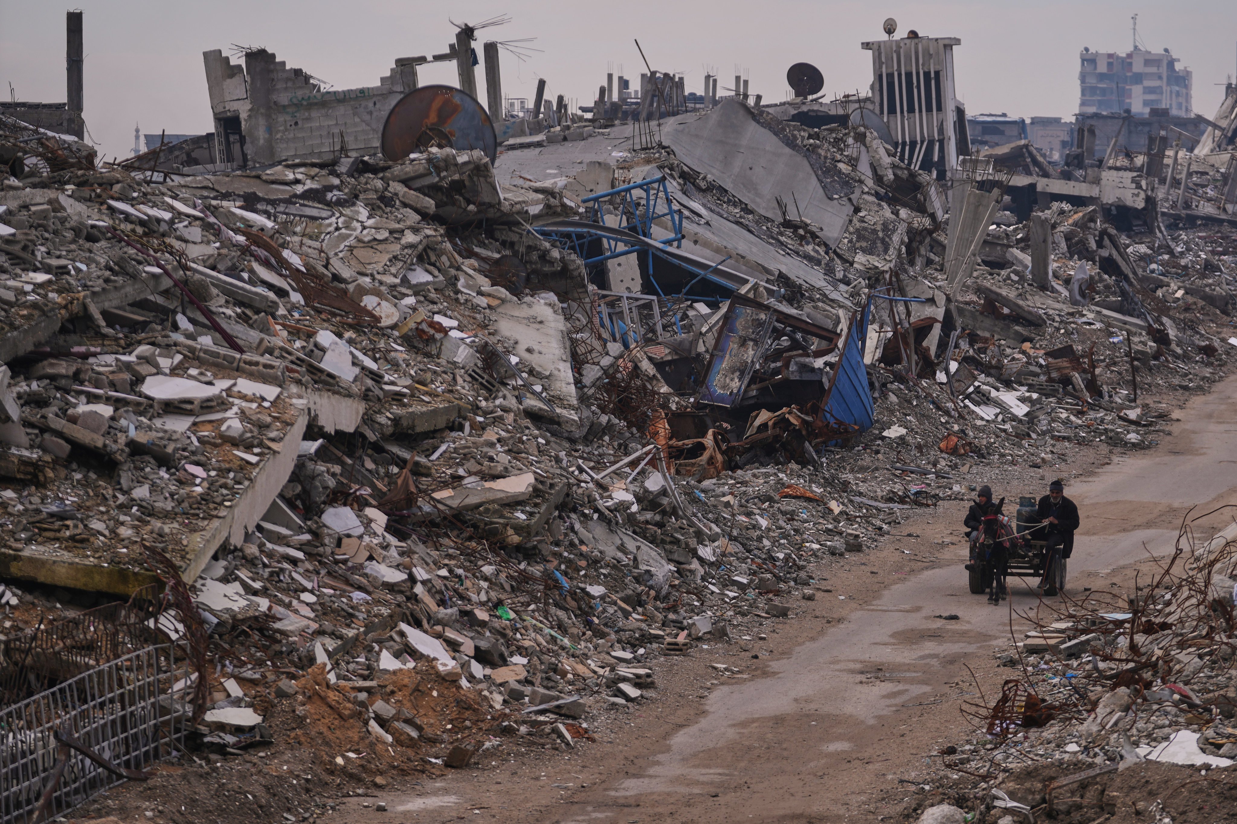 Palestinians pass along a street surrounded by buildings destroyed during Israeli air and ground operations in Gaza City. Photo: AP
