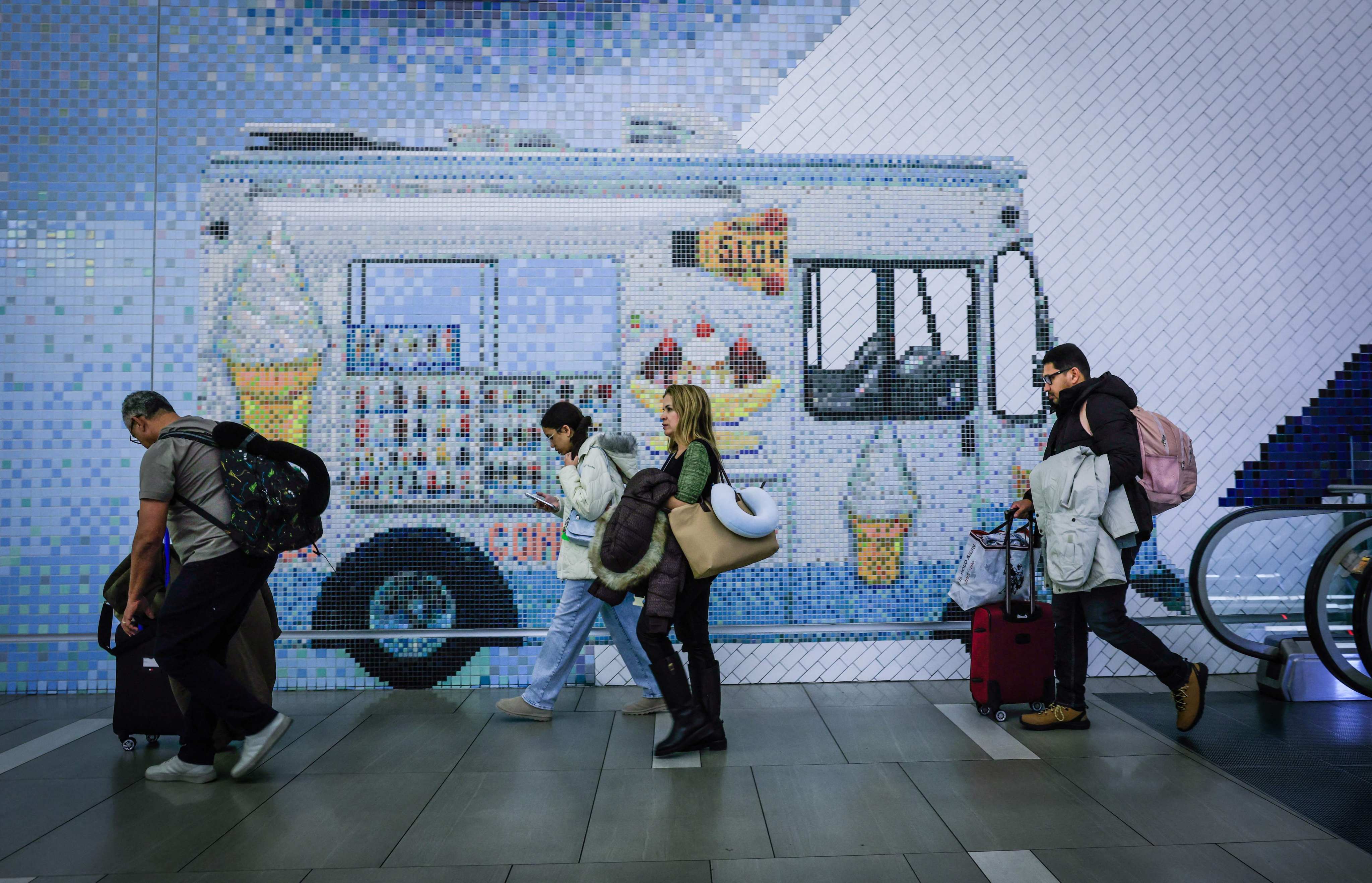 Travellers walk through the arrival hall at La Guardia Airport in New York on December 23, 2025. Photo: AFP