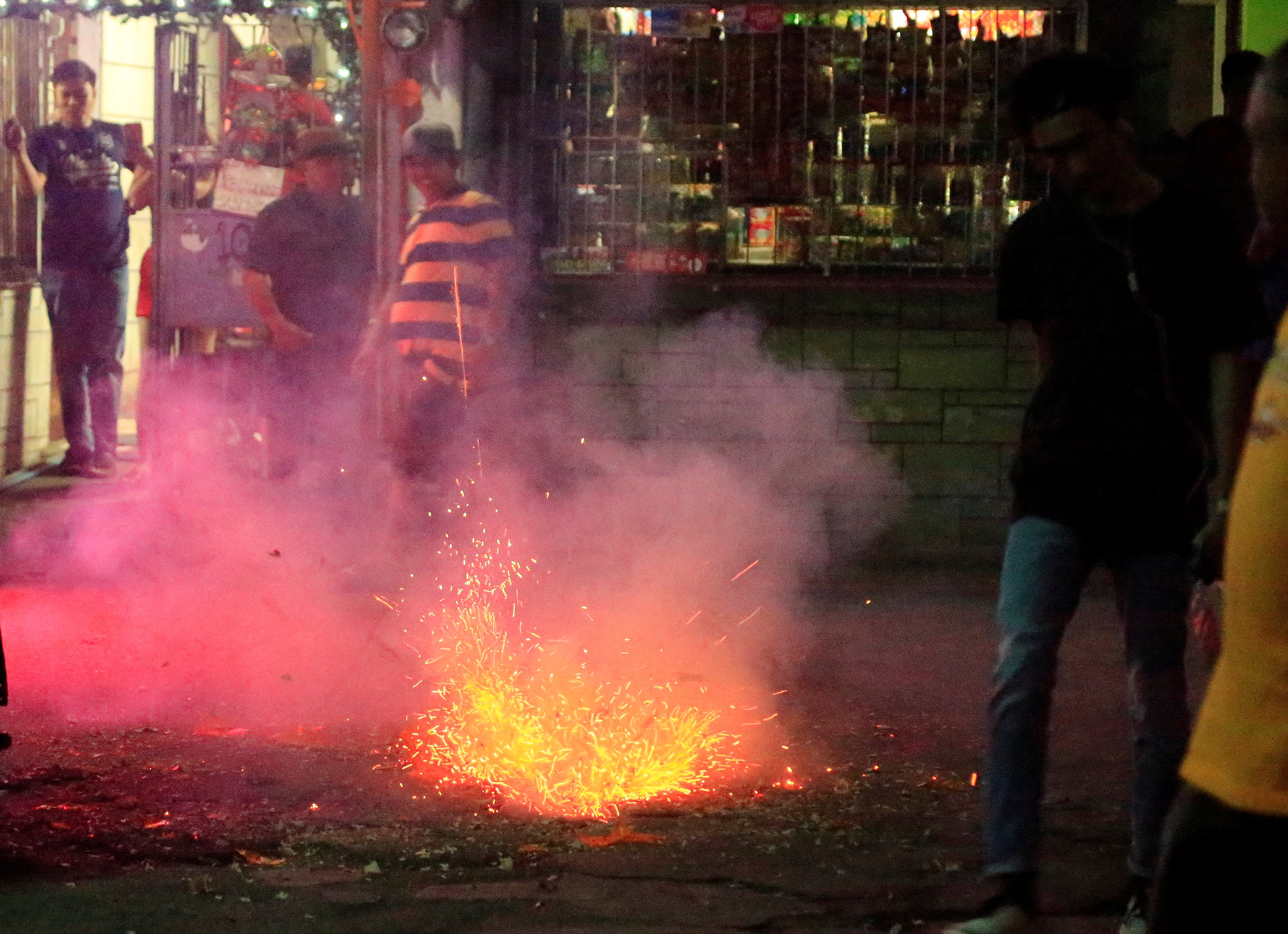 Residents watch firecrackers on New Year’s Eve, exploding to welcome 2018 in Paranaque City, Manila, Philippines. Photo: Reuters