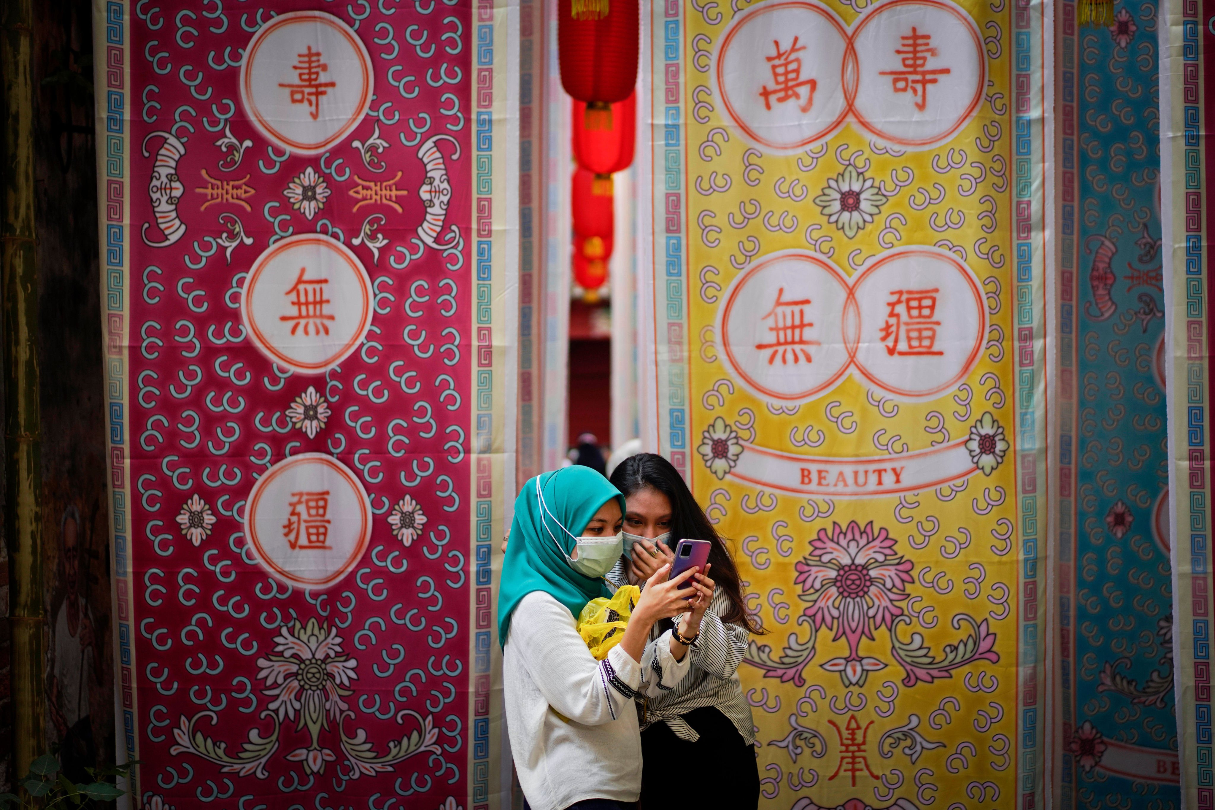 Young women using a smartphone in Kuala Lumpur, Malaysia. From January 1, major social media and messaging platforms with more than eight million users in Malaysia are treated as licensed under a new online safety regime. Photo: AP