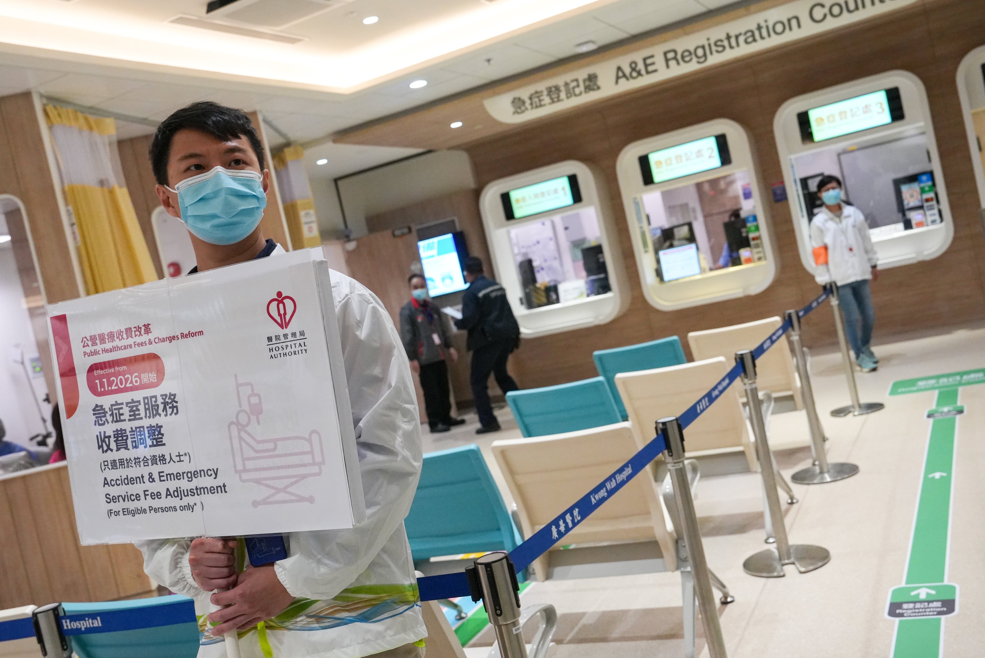 An employee at Kwong Wah Hospital holds up a sign explaining the fee revamp. Photo: Sun Yeung