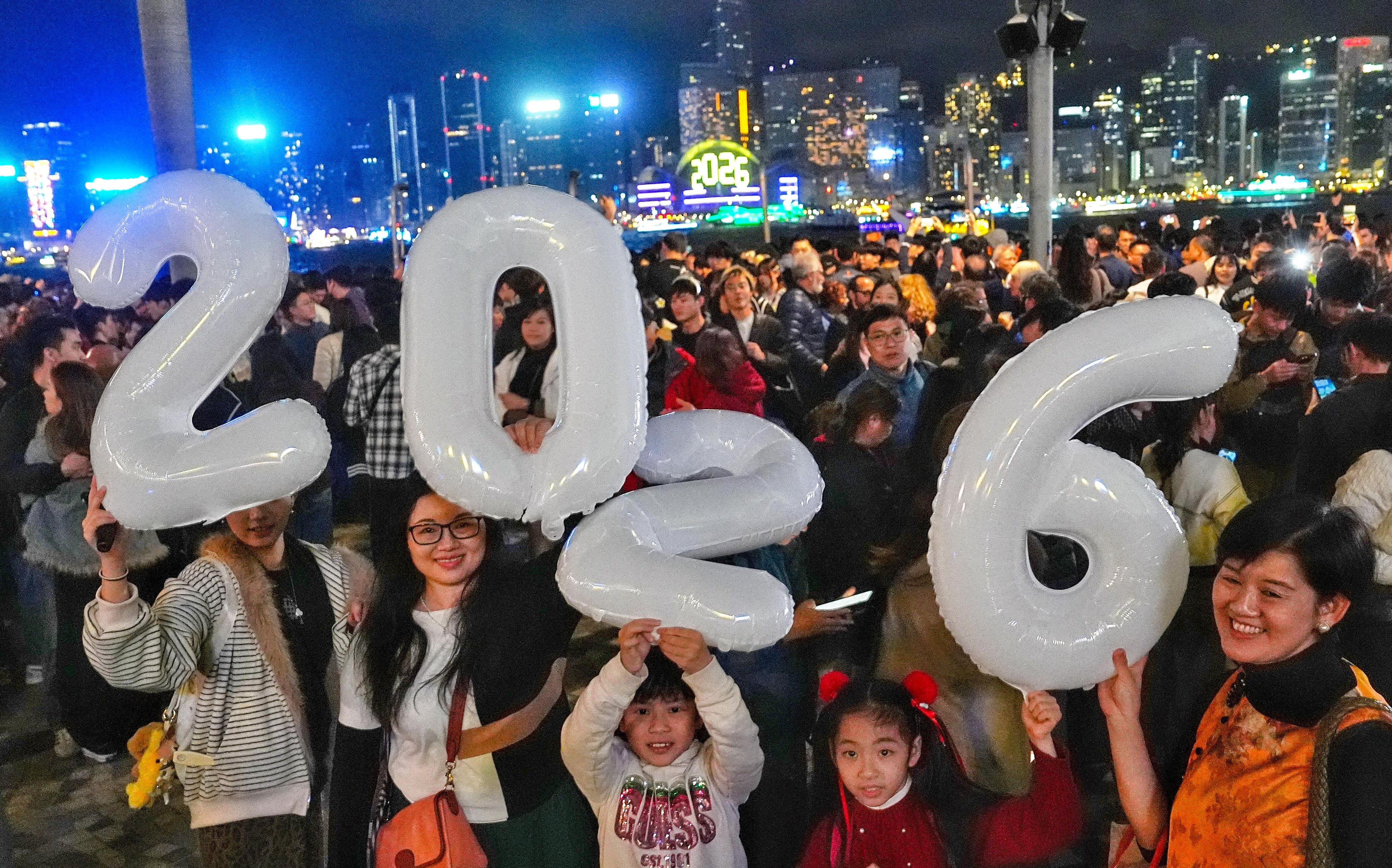 A family holds aloft festive balloons to mark the new year. Photo: Elson Li