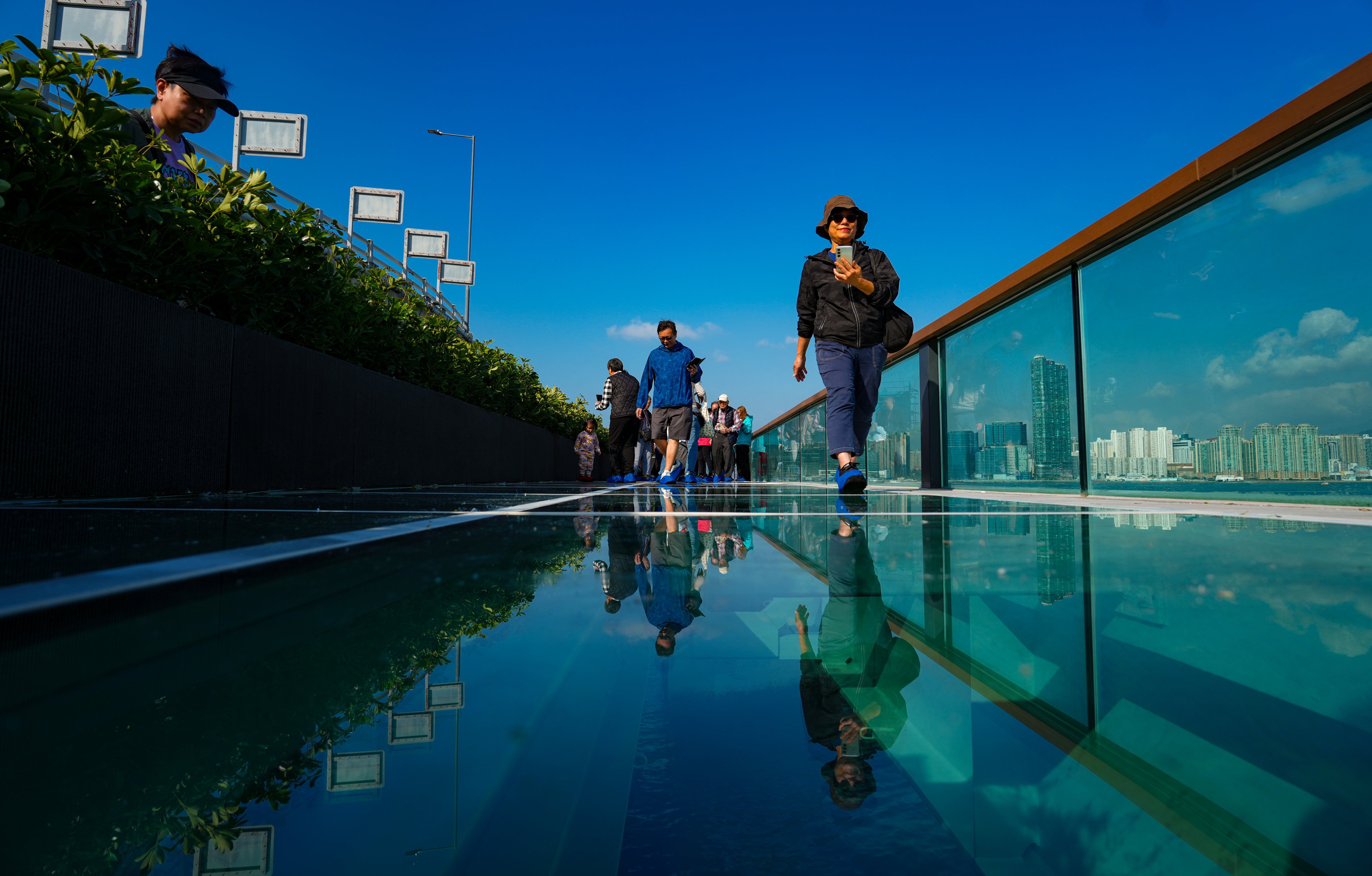 People walk on the glass floor of the eastern section of the East Coast Boardwalk in North Point on December 29. Photo: Sam Tsang