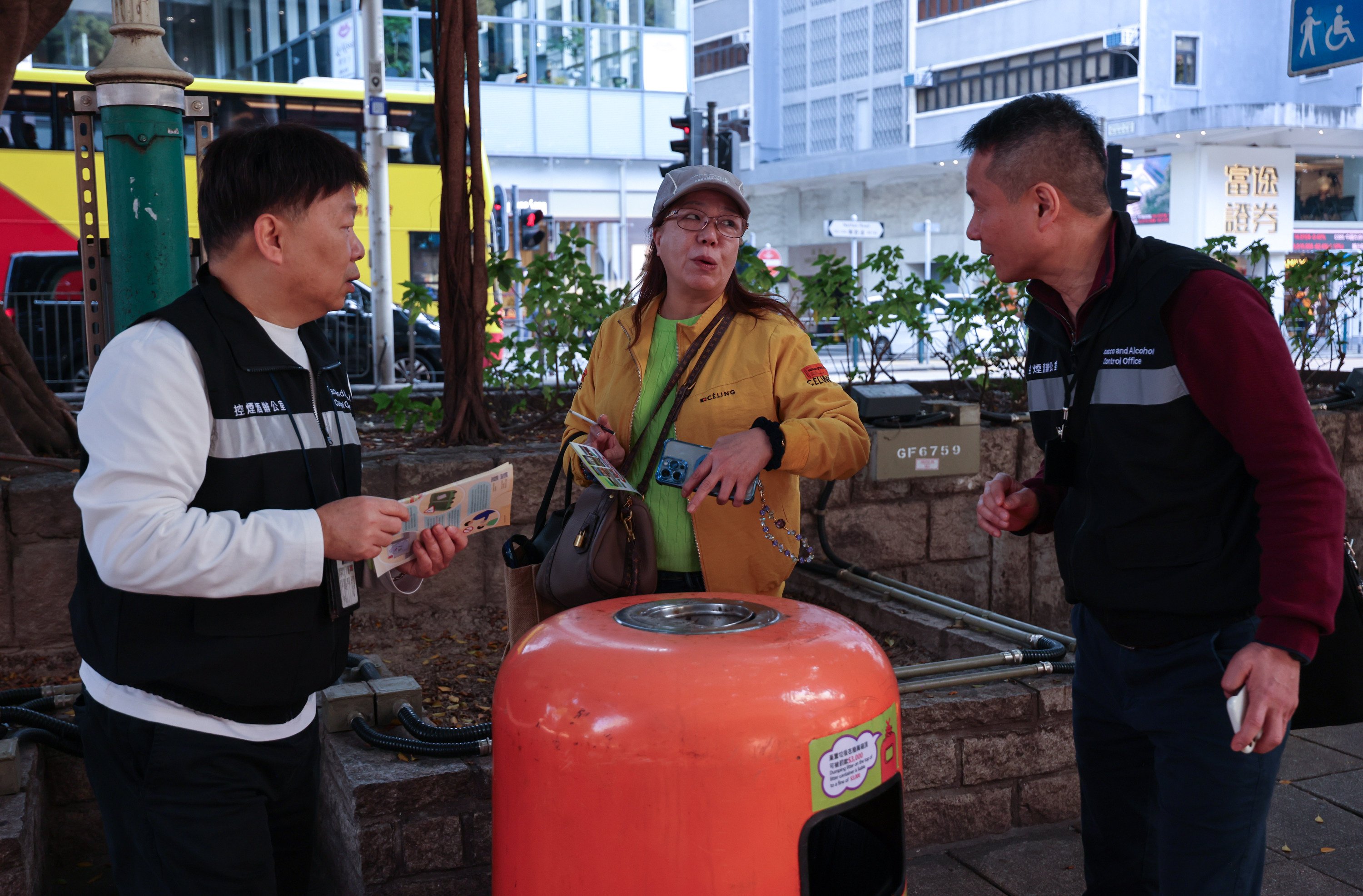 Tobacco and Alcohol Control Officers distribute leaflets on the new restrictions on public smoking to a tourist in Tsim Sha Tsui on Thursday. Photo: Jelly Tse