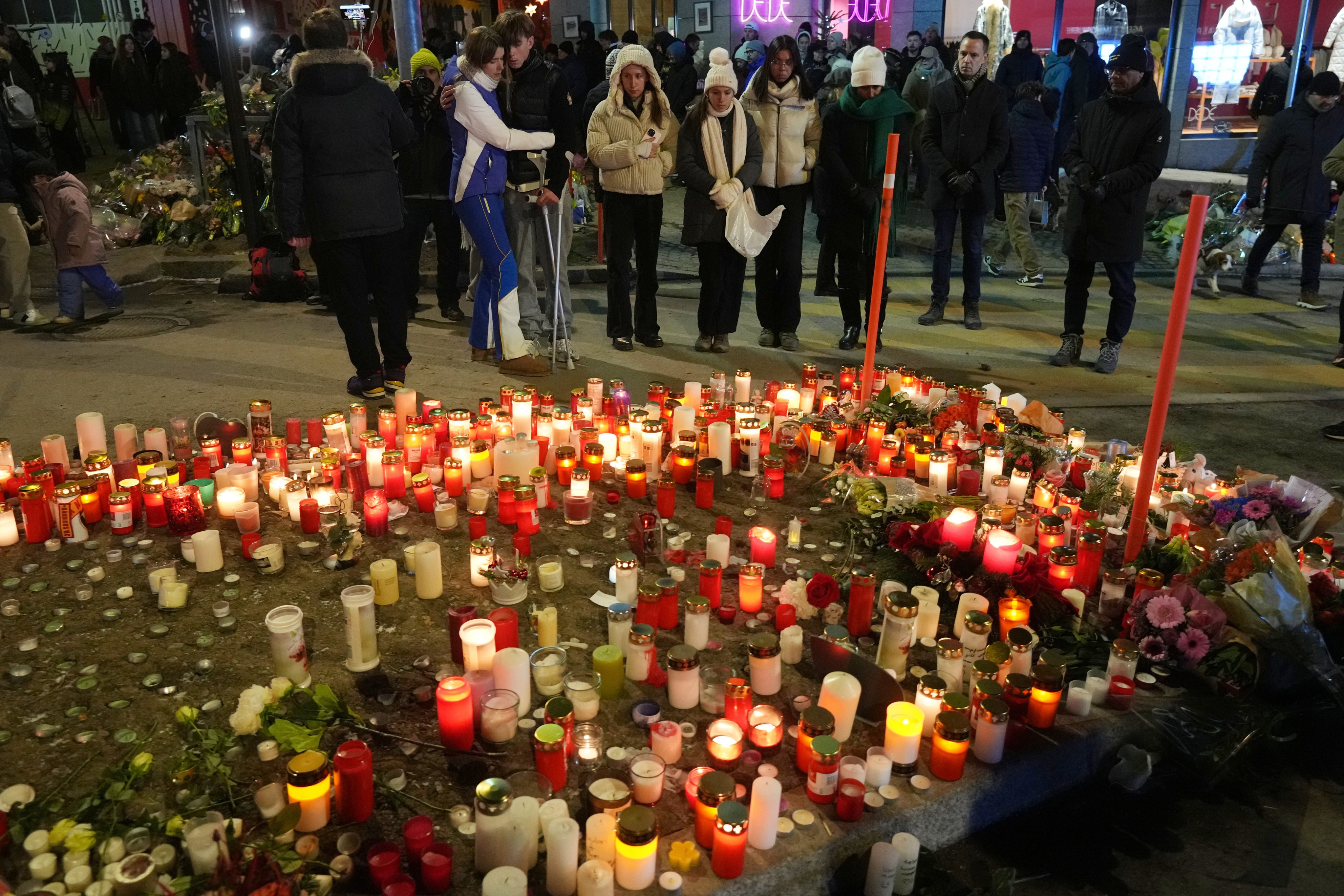People light candles near the sealed Le Constellation bar in Crans-Montana, Switzerland on Friday where a devastating fire left 40 dead and dozens injured during the New Year celebrations. Photo; AP