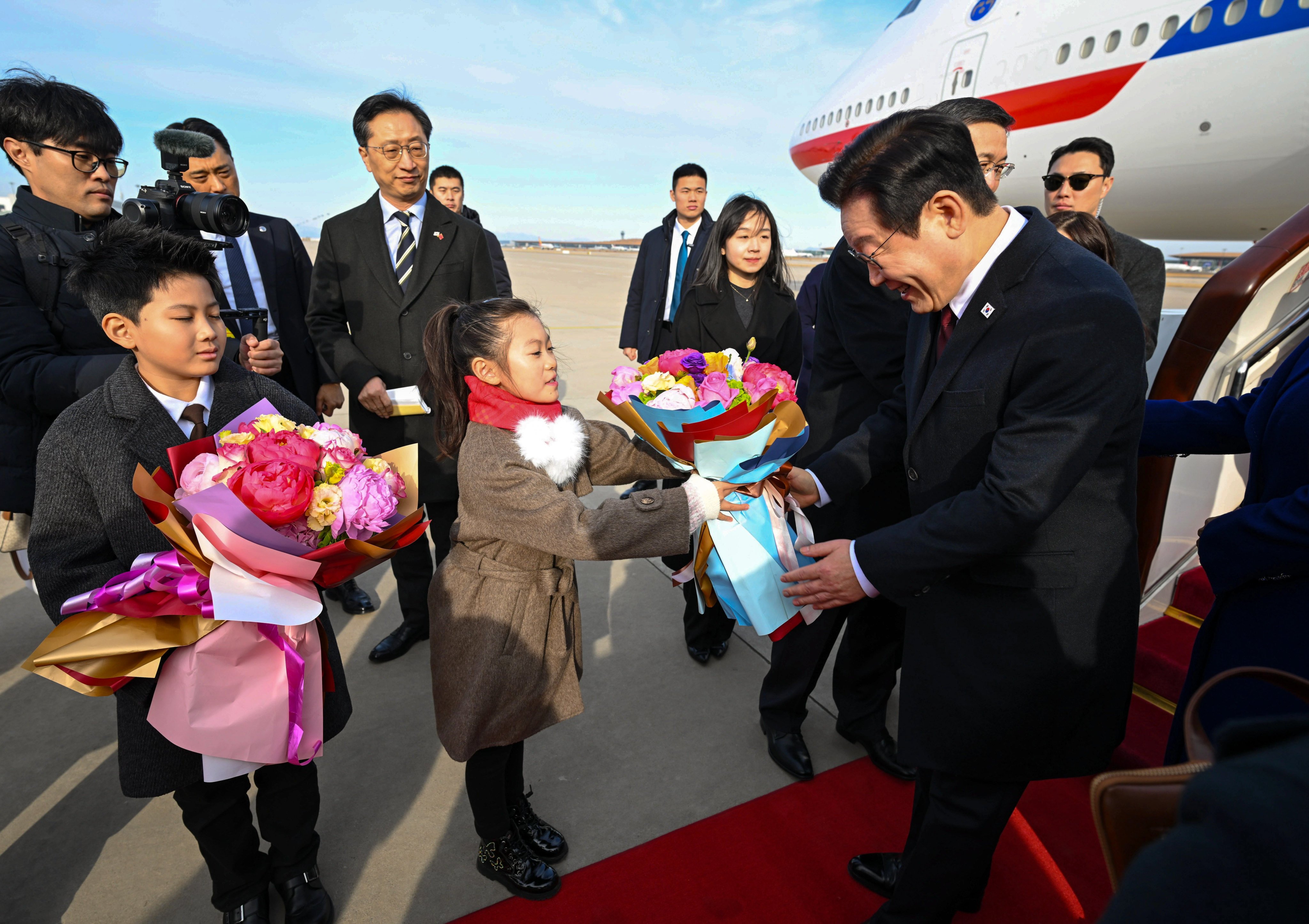 Children greet South Korean President Lee Jae-myung upon his arrival in Beijing on January 4. Photo: Xinhua