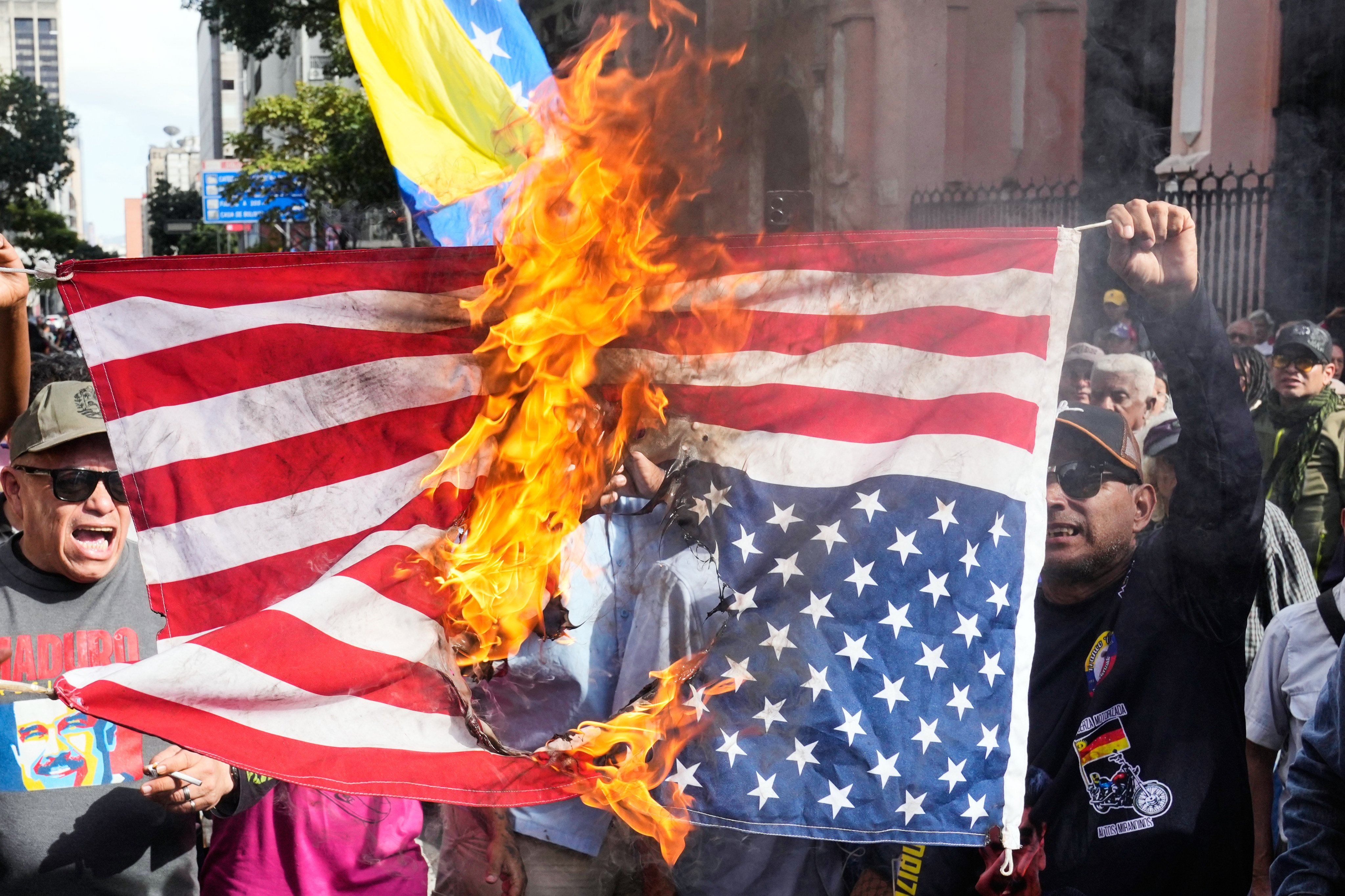 Venezuela government supporters burn a US flag in Caracas on Saturday. Photo: AP