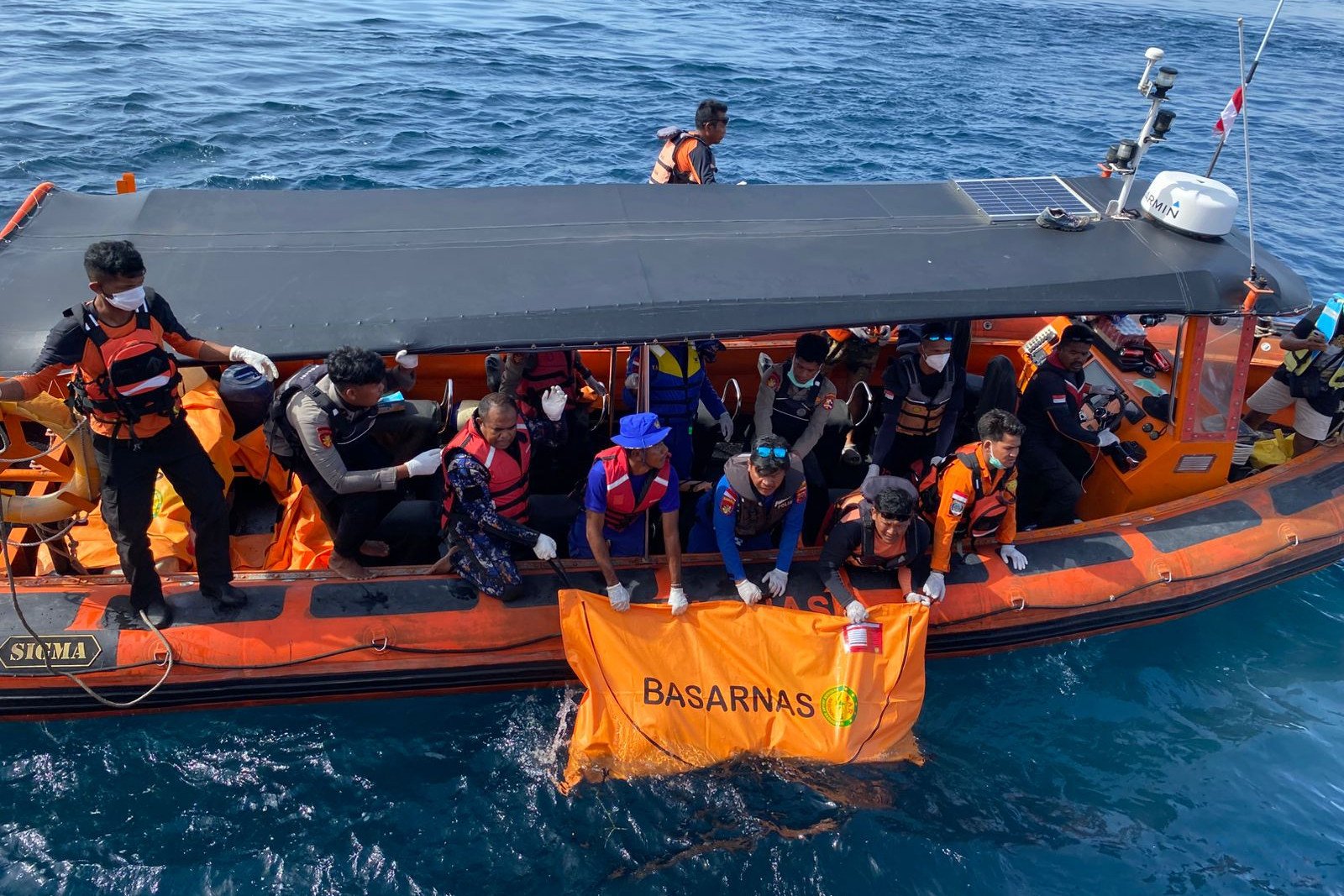 Indonesian rescuers on Sunday recover a body believed to be one of the victims of a tourist boat that sank on December 26.  Photo: Basarnas/AP