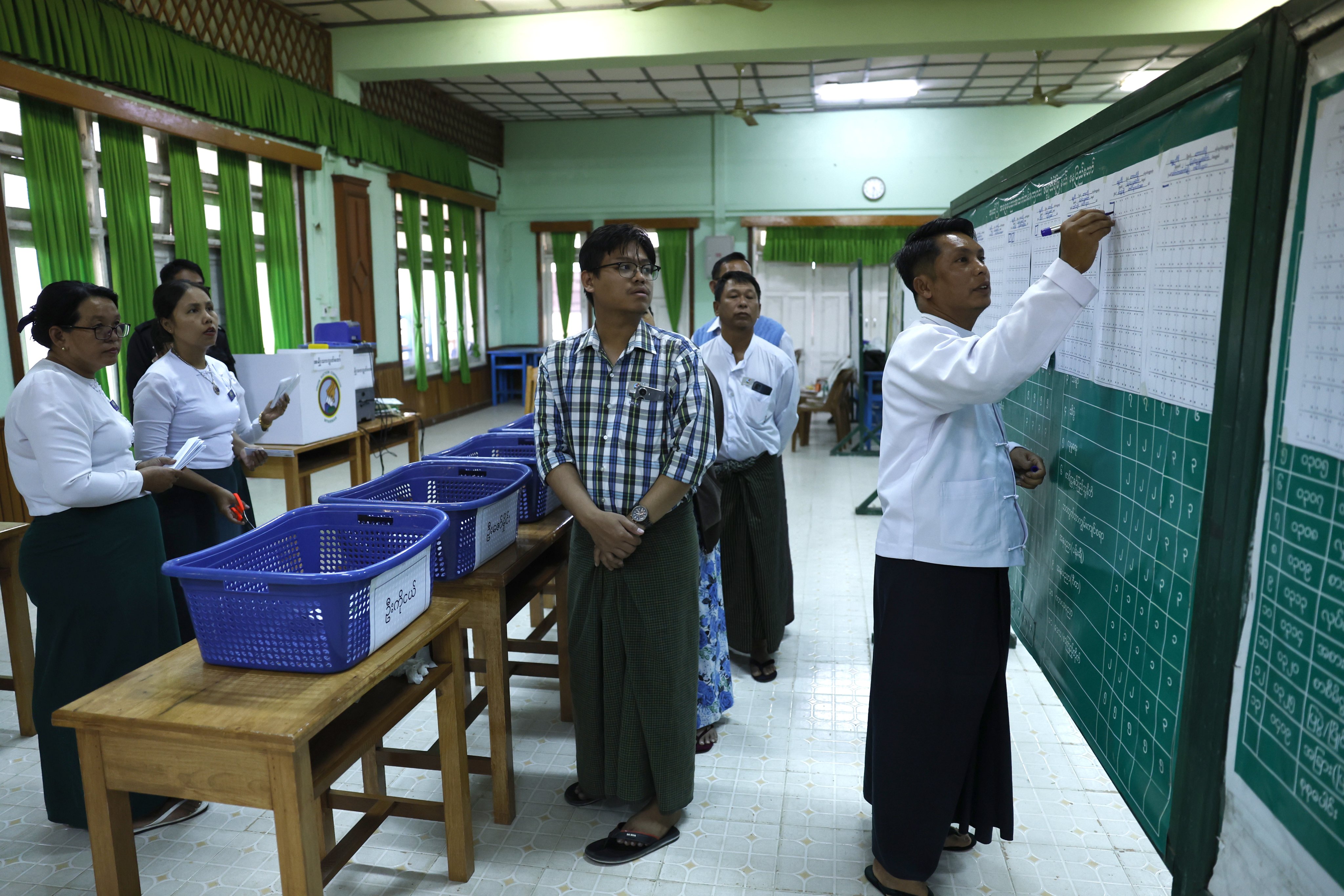 Myanmese electoral officers count early voting ballots at a polling station in Naypyidaw on December 28. Photo: EPA