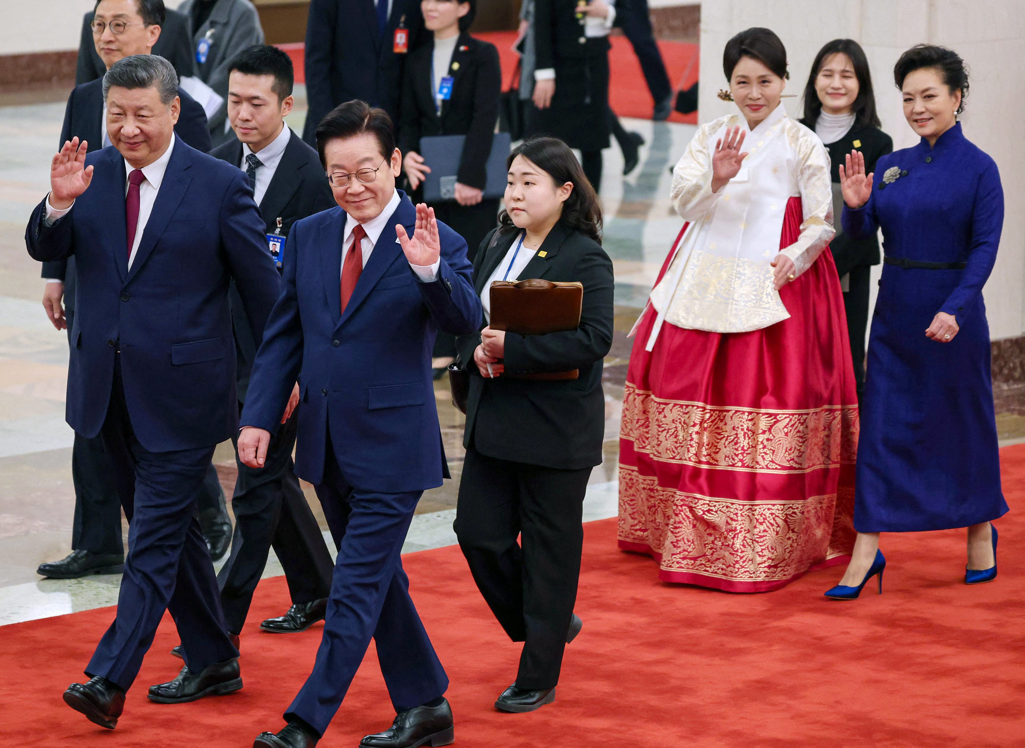 South Korean President Lee Jae Myung walks alongside Chinese President Xi Jinping as their spouses follow behind, during a welcoming ceremony in Beijing on Monday. Photo: AFP