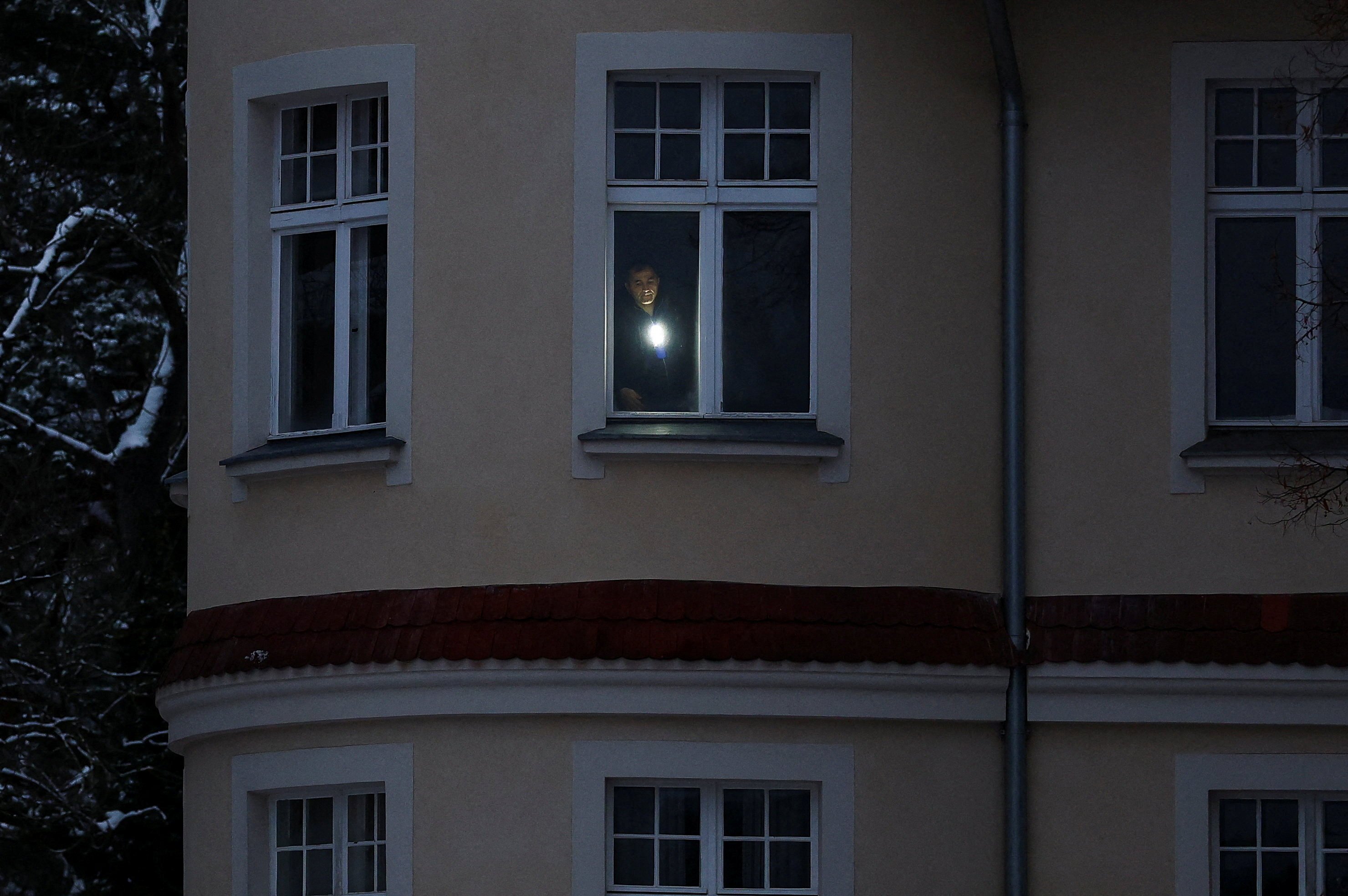 A man uses a torch in his flat during a blackout that left thousands of homes without electricity. Photo: Reuters