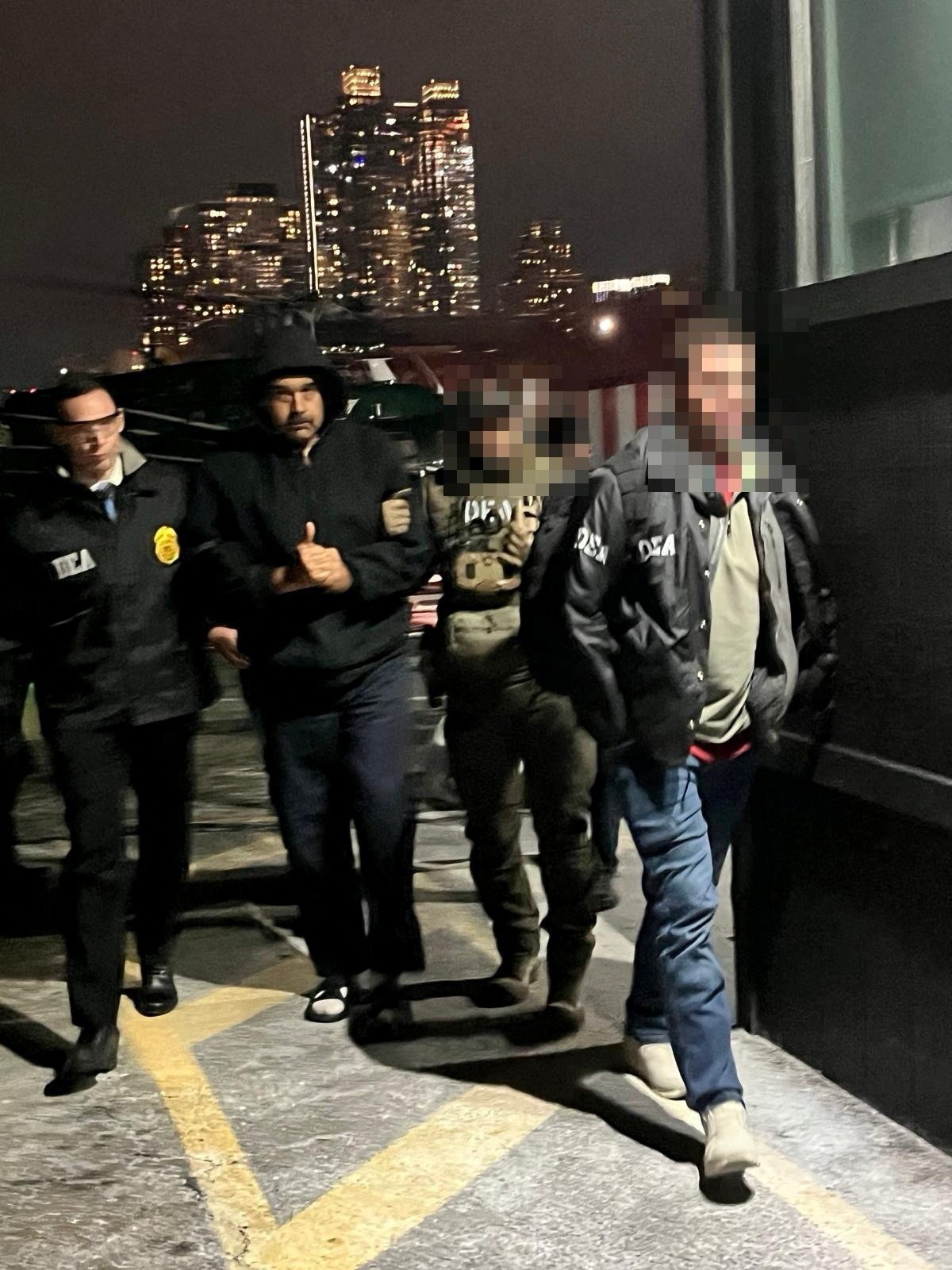 Venezuela’s captured President Nicolas Maduro is led by US Drug Enforcement Administration agents after arriving at a heliport in New York City on Saturday. Photo: Handout via Reuters