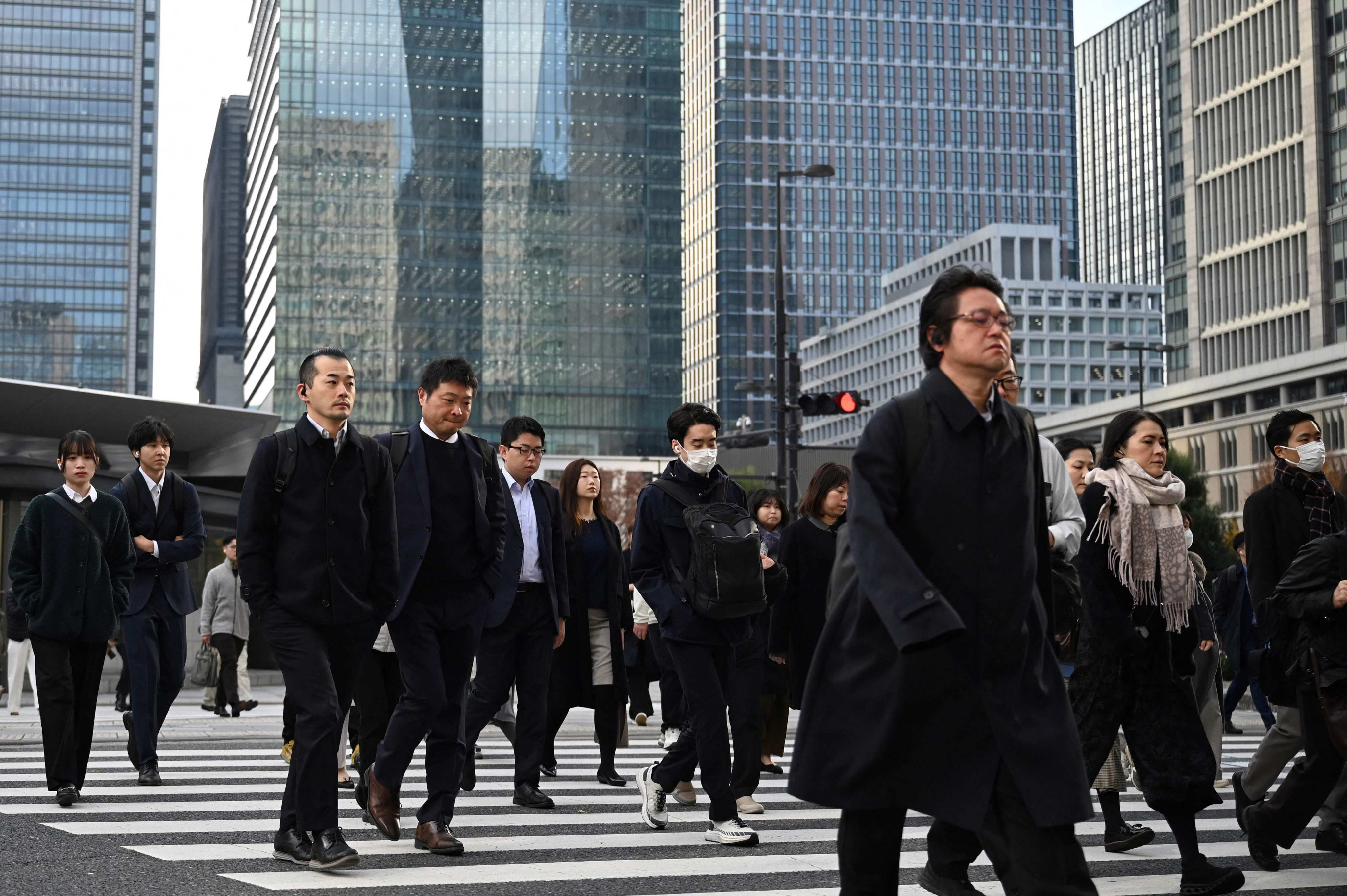 People cross a road near Tokyo station. The rising popularity of corporate-only dating apps in Japan comes as its birth rate continues to fall. Photo: AFP