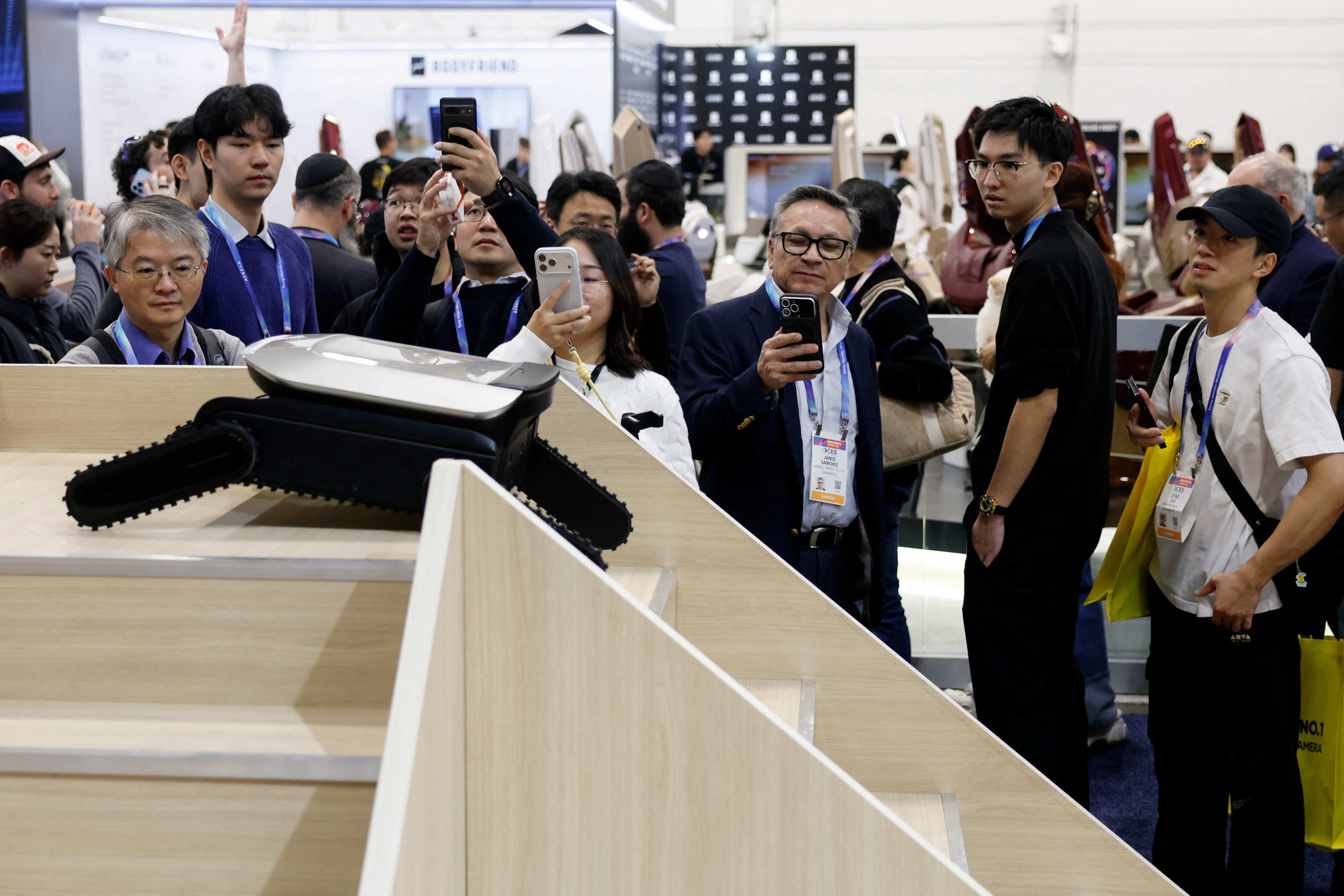 People at the CES trade show watch Dreame’s prototype Cyber X robot vacuum cleaner, the first such product designed to climb up and down an entire flight of stairs and handle multilevel cleaning. Photo: AFP